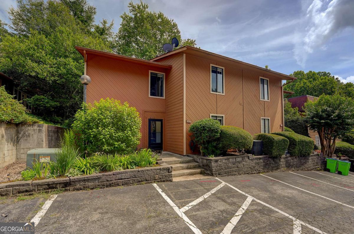 Spacious 2,000+ sq ft, 4-bedroom, 3-bath townhome-style condo in Spinnaker Cove-minutes from Marietta Square. This renovated corner unit offers abundant living space in a private lake community with modern upgrades and thoughtful details. Live in comfort, convenience, and community! Prime Location: Less than 3 miles to historic Marietta Square, offering dining, shopping, and entertainment. Private Lake Community: Peaceful setting with a lakefront swimming pool, clubhouse, fenced dog park, and ample visitor parking. Outdoor Living: Fully fenced backyard-sunny in winter, shaded in summer-with lush perennial gardens, a spacious leisure area, and a generous screened patio accessible from the living room via French doors. Smart Safety & Security: Keypad deadbolt at the front entry for secure, keyless access; community streetlight illuminates the walkway and parking at night; motion sensor light keeps the backyard well-lit after dark. Main Level Convenience: Fully enclosed entry, a walk-in closet by the front entrance-ideal for storage or as a butler's pantry-and a large main-level bedroom with ensuite washroom and separate toilet/bath. Open & Inviting Main Floor Plan: Dining room with crystal chandelier and built-in solid wood, granite-topped writing desk. Adjoining spacious living room features built-in floor-to-ceiling bookshelves, gas-starter fireplace, and direct access to the screened patio. Restored Chef's Kitchen: Reclaimed red oak cabinetry, extra-large island, granite countertops, LED-lit black marble backsplash, and stainless steel Samsung SmartThings appliances (fridge, microwave, dishwasher). Includes a stainless steel garden sink with retractable hose and additional built-in open pantry shelving. Upstairs Retreat: Extra-large primary bedroom features ensuite walk-in closet and full bath with his-and-hers marble vanity sinks and a separate toilet/bath area. Two additional bedrooms-one with mirrored closet doors (ideal as an office), another with a spacious walk-in closet. All bedrooms include remote-controlled lighting and ceiling fans. Shared hallway bath offers a dual marble vanity and separate toilet/bath room. Laundry & Storage: Dedicated laundry area with Samsung SmartThings washer/dryer and shelving. Spacious linen closet and separate supply closet nearby. Smart Home Features: Dining room chandelier, kitchen overhead light, and living room ceiling fan light are all smart, dimmable, and programmable via Wi-Fi. All Samsung SmartThings appliances are Wi-Fi enabled for remote control and notifications. Comprehensive, Active HOA: HOA maintains all common areas, building exteriors, and front yard landscaping. Monthly assessments cover water, sewage, trash and recycling, termite service, and hazard insurance. Residents enjoy monthly virtual HOA meetings, neighborhood gatherings, newsletters, and a Facebook group. Recent upgrades include new retaining walls, sewer lines, and asphalt replacement-all funded by regular assessments.
