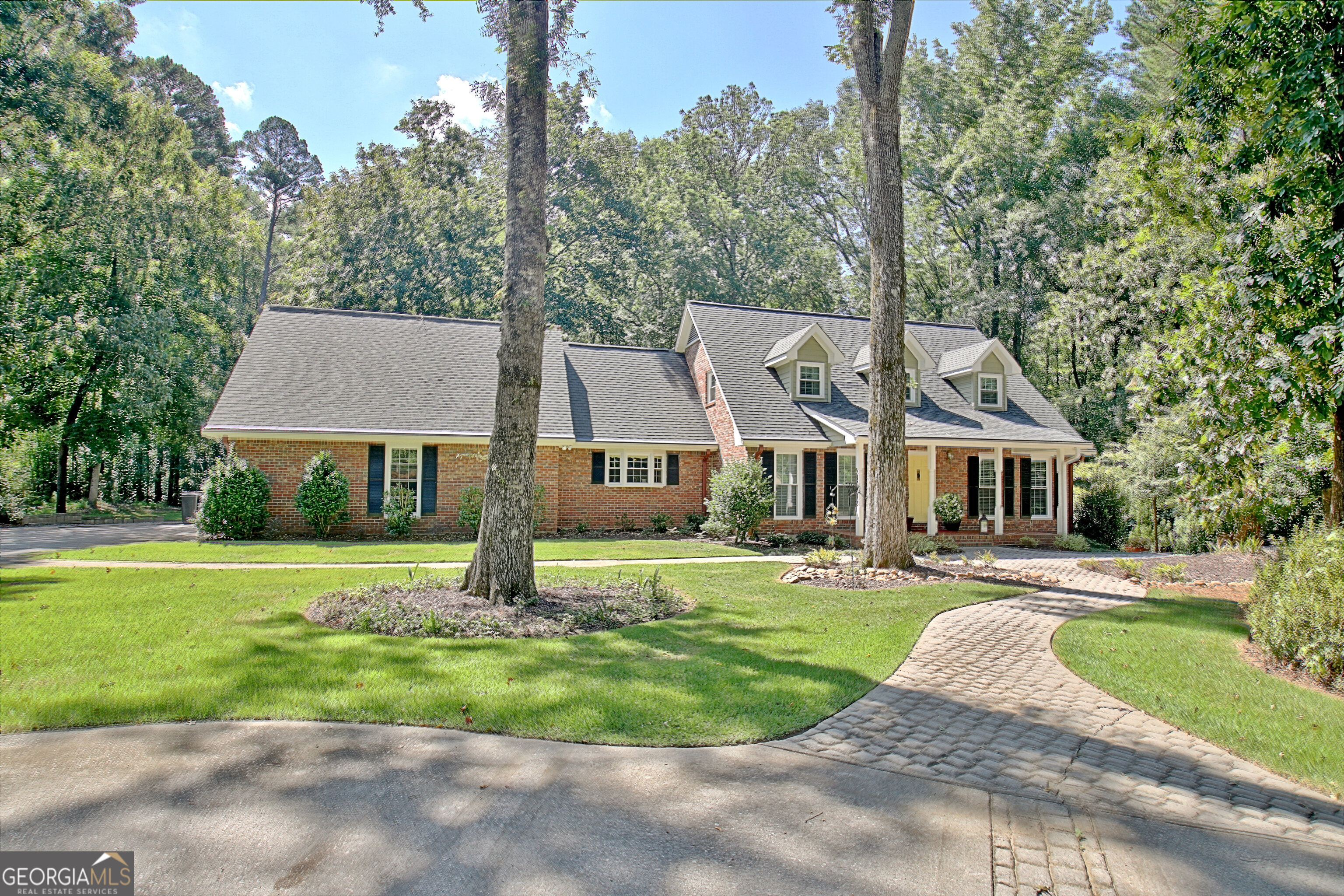 Check out this Great Deal! Large full brick home on over 3 acres. This home is in the back yard of Trilith and still feels like luxury country living. Time to put your personal touches on and make this the place of your dreams with location plus. Enter from a rocking chair front porch into the living room with formal dining to the left. The family living suite is a great place to unwind with an open kitchen and family room design. The owner's suite is on the main level with a walk in closet and standard closet with closet system. The bath has ample space for a shower, jetted tub and 2 vanities. Ample room for 2. One additional bedroom on the main level, or it could be an office plus the laundry room and a full bath right off of the 2 car garage. The family room opens wide with french doors onto the oversized screened porch, a great place to relax and watch nature or maybe have dinner and unwind after work. Upstairs there are 2 additional bedrooms with a tiled hall bath that boasts a linen closet. There is also a small office upstairs which is great for homework or paying bills in a private space. The basement has been completed and is ready for some good times. It has a huge great room that opens to the rear yard plus an additional bonus room and a family room with huge bar & gas log fireplace. Terrace level opens to a large stone patio for outdoor entertaining. The level yard in the front with a circular drive gives the owner a lot to be proud of and is very welcoming. The back yard backs up to the creek and who doesn't love a private nature space to roam on their own property. The home has new windows and doors throughout with a few exceptions, 2 septic systems, central vacuum, custom blinds, new water heater in 2024 & new sump pump for downstairs kitchen. Wildlife abounds and the owner feels as if they are many miles away from the city yet everything is right at their fingertips. Come view this property and see how this would make a great home for your family. Priced to move! Don't wait!