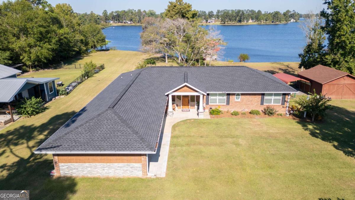 Welcome to lakefront living! This beautiful 3 bedroom, 2 bathroom home features a remodeled kitchen with new cabinets and appliances along with an added island with columns and stone. Other renovations include new siding, windows, doors, vinyl flooring throughout, and an updated primary bath with tiled shower and new vanity. A glassed-in porch with French doors, split AC, and wood walls adds year-round enjoyment. A new roof and HVAC unit were added in 2024. Outside you will find a fenced in yard with a spacious back porch with gorgeous water views, a TREX deck with stone accents and privacy panels, a private boat ramp, and a lakeside sitting area. Move-in ready and perfect for lake life! *boat house is apart of the neighboring property and not included with this listing*