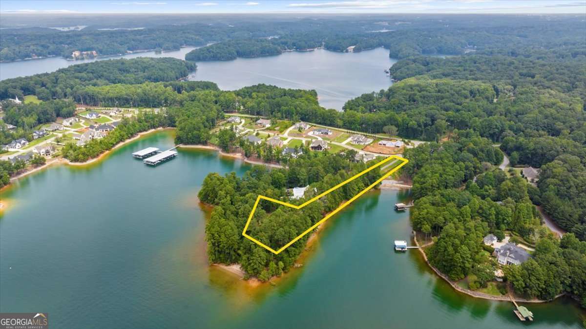 Positioned within the sought after Bay Pointe community, this extraordinary 1.51 acre lake lot with Private drive, Gated access, and Fence offers an unrivaled setting for your custom estate. Surrounded on three sides by water, with more than 1200 feet of pristine shoreline, a Corps of Engineers walking trail and sandy beaches. the property combines natural beauty and panoramic views with exclusivity and privacy. From sunrise reflections to sunset horizons, every vantage point captures the essence of luxury lakefront living. With a build-ready homesite, you have the rare opportunity to create a residence tailored to your lifestyle-whether it's a contemporary retreat with walls of glass, or a timeless lakefront sanctuary. This is more than a lot; it's the canvas for your legacy on the water. Deeded 12 X 28 boat slip, on Dock A, slip 22, provides an easily accessible position. The Community Dock has water and power, and is golf cart accessible. Quick access to Atlanta via I-985/I-85. Water and electric are on site. Septic needed. House plans are available upon request. Don't miss this opportunity to own your private paradise. Weissman is the preferred closing attorney.