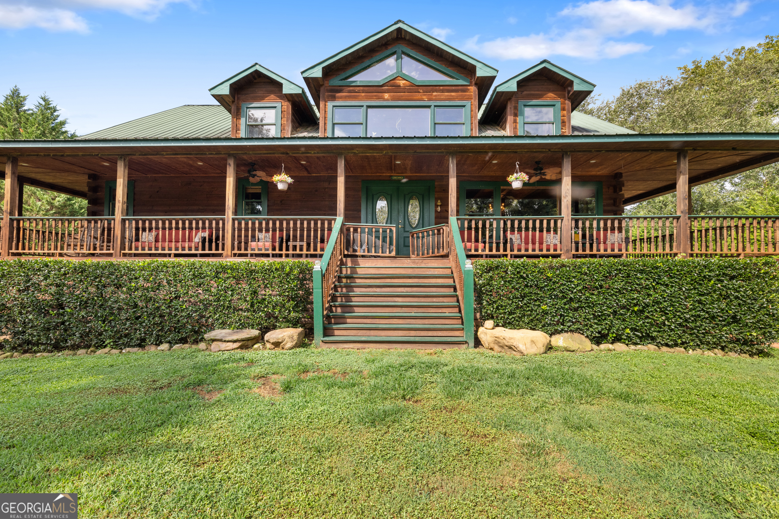 This stunning riverfront log home on the premier trout-filled Hiawassee River in Western NC and North Georgia is an angler's dream with incredible frontage and breathtaking views. Featuring a durable metal roof, the property boasts a fenced, level front and back yard-perfect for pets to roam and play. The 4-bedroom, 3-bath, 1-half-bath home offers one-level living on the main floor with an open-concept layout, rustic elegant design, big ceiling beams, marble kitchen countertops, and gleaming wood floors. A massive floor to ceiling wood-burning fireplace anchors the space, while a loft with 2 bedrooms and a bath overlooks the main level. The downstairs includes a wet bar, game area, garage, and an additional bedroom and bath. Wrap-around porches provide serenity for entertaining friends and family. Conveniently located near National Forest Service land, Lake Chatuge, and several golf courses, this home is a perfect blend of luxury and outdoor adventure.
