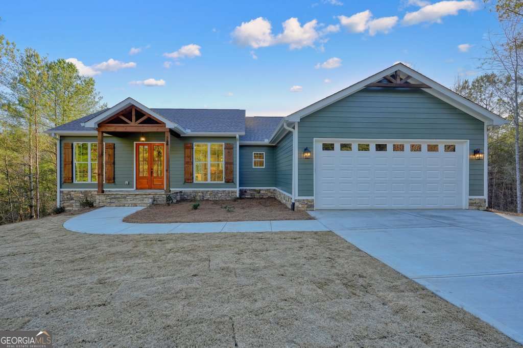 Nestled in a peaceful setting with no HOA in the desirable Hunters Ridge subdivision, this stunning 3-bedroom, 2.5-bathroom home sits on over 1 acre of beautifully landscaped land with lush Bermuda grass. Offering a perfect blend of modern upgrades and timeless charm, the spacious open-concept design features a large kitchen with white cabinetry, quartz countertops, a brick backsplash, and a walk-in pantry, seamlessly flowing into the great room-ideal for entertaining or family gatherings. The oversized master bathroom is a true retreat, complete with a rainfall shower, soaking tub, and beautifully tiled shower. Enjoy outdoor living on the two back decks, one on the main level and one on the basement level, offering serene views of the private yard. The full basement, already stubbed for additional bathrooms, provides endless potential for customization. This home combines modern convenience with tranquility, making it the perfect place to call home.