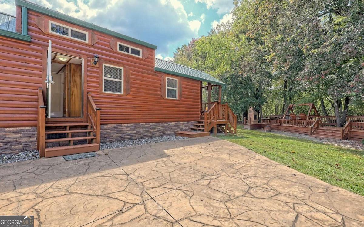 Experience the ultimate mountain escape with this beautifully appointed park model cabin, perfectly situated in the highly sought-after Crossing Creeks RV Resort. Set along the peaceful banks of Anderson Creek, this inviting retreat offers a rare blend of comfort, charm, and natural beauty - the ideal getaway or income-generating investment. Step inside to find a warm and welcoming interior, thoughtfully designed for both relaxation and functionality. The real magic happens outside, where a spacious creekside deck invites you to unwind beside the custom outdoor fireplace - the perfect setting for cozy evenings, morning coffee, or entertaining guests to the soothing soundtrack of flowing water and birdsong. Surrounded by the resort's upscale amenities and framed by the tranquil beauty of North Georgia's mountains, this cabin is your gateway to a life of adventure, serenity, and connection to the outdoors. Whether you're looking for a personal retreat, a vacation rental opportunity, or both - this unique property is a rare find that won't last long. Don't miss your chance to own a piece of paradise!
