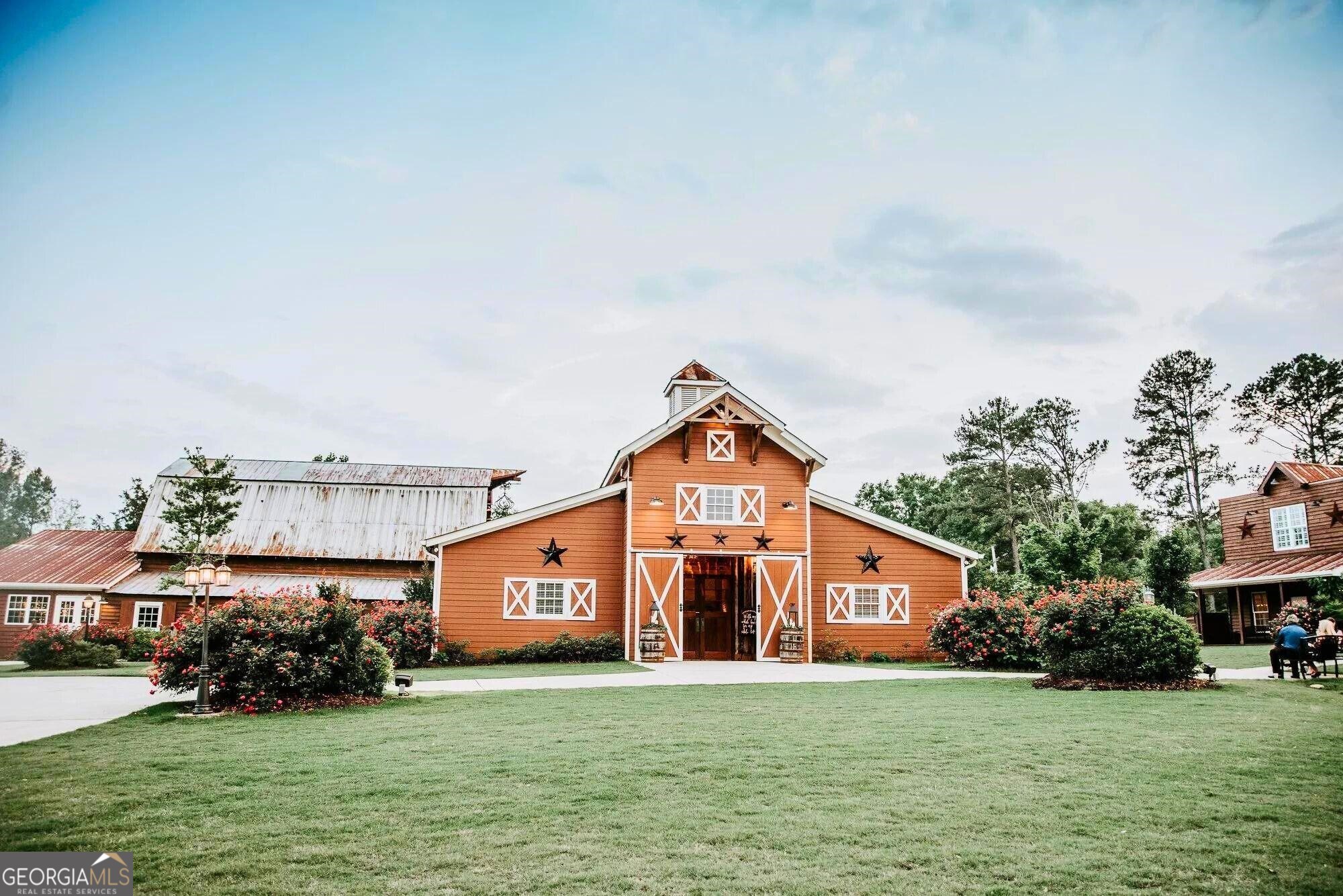 This 48.17-acre property includes three event venues, five guest houses and a 10k SF warehouse/storage building. The property has approximately 2,000 feet of frontage along State Highway 83 that allows individual access to each venue so they can be rented separately and at the same time. The back of the property is elevated and heavily wooded to offer seclusion from neighbors. The sale price includes the fee simple real estate with improvements, the wedding and event venue business with FF&E and the guest houses. Event and rental deposits in hand on the day of the sale will be credited to buyer at closing.****** PROPERTY HIGHLIGHTS: 48.17 acres with good topography and heavy woods along property lines. Located in an unincorporated area of Walton County, GA.  Zoned A-1, Rural Estate District by Walton County. Walton County tax parcel ID: C1800023B00 with 48.17 acres.  9 septic systems. 2 water wells and public water.***** WEDDING & EVENT BANQUET HALLS: The 9 Oaks Barn with 7,401 SF. The White House with 3,510 SF on the first floor, 416 SF on the second and three covered porches. The 2425 Warehouse with 5,616 SF on first floor, 1,296 SF on second floor, a 1,496 SF covered pavilion and a 702 SF covered front porch.*****  GUEST HOUSES: The Red House with 1,457 SF on first floor, 1,102 SF on second and an 842 SF covered porch. The Bridal Suite with 1,392 SF on the first floor, 1,108 SF on the second, a 580SF covered front porch and a 192 SF covered side porch. The Tin House 1,020 SF on the first floor, 680 SF on the second with a large 1,092 SF covered porch. The Cottage with 400 SF and two 120 SF covered porches. The Cabin with 560 SF and two covered porches of 200 SF.*****  BLUE WAREHOUSE: 10,560 SF metal warehouse with a finished apartment.*****  OTHER MINOR IMPROVEMENTS: Tractor barn. Pump station. 16' x 24' storage building. 12' x 30' storage building.