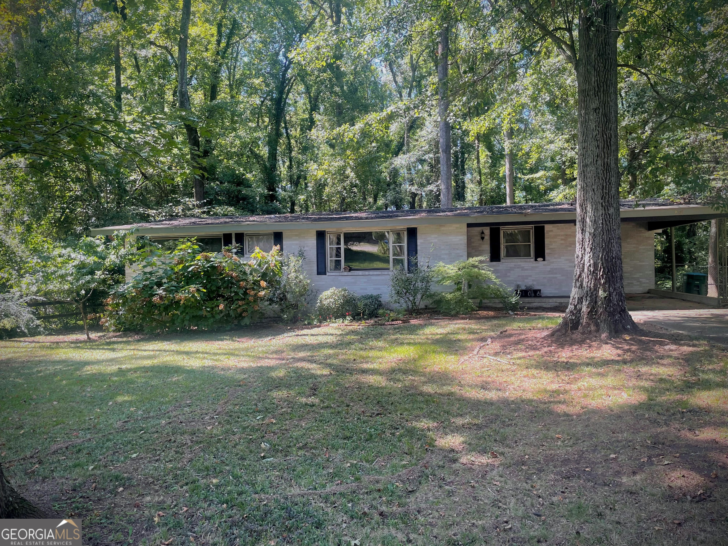 Welcome to 208 Springtree Rd., a charming mid-century all-brick home on the Eastside of Athens, GA. While adjacent to the Gaines School Rd commercial corridor, as well as the UGA Campus, the neighborhood is pleasantly quiet and the home is situated on a large (1/2 acre) lot with mature shade trees and fenced backyard. Upon entering the front door, you will notice the vaulted ceiling and exposed wood beams that add to the character of the home, as well as its beautiful hardwood flooring. There is a small dining area adjacent to the main living area that opens into the kitchen, which has ample countertop space and a breakfast room. Beyond the breakfast area you will find a den with lots of windows overlooking the backyard, and a woodstove, perfect for cozy relaxation during cooler months. On the opposite side of the home are two bedrooms and one full bathroom. The primary bedroom also has an ensuite half bath. The backyard has a few raised beds, perfect for your gardening endeavors! This home is very close to Eastside shopping and dining and within a quick car-ride of UGA Campus and Downtown Athens.