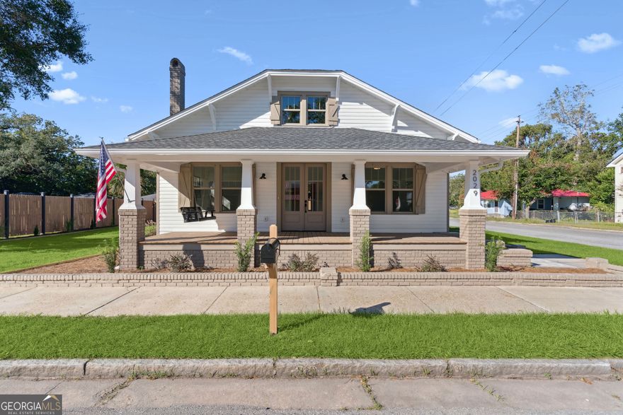 Experience the charm of Historic Downtown Brunswick in this fully renovated Craftsman-style home, ideally located just one block from the Brunswick Landing Marina and Veterans Memorial Park, and an easy stroll to the shops, galleries, and restaurants of Historic Downtown Brunswick. This corner-lot residence blends timeless architectural character with modern luxury. The home has been completely reimagined-nothing left untouched. Inside and out, enjoy a freshly painted exterior and interior, a 2-year-old roof, new HVAC, new plumbing and electrical (including nightlight feature fixtures), new double-pane windows, batt and blown-in insulation, and a tankless water heater. Step onto the rocking-chair front porch with its charming porch swing, then enter into a bright and inviting living area featuring a fireplace with ventless gas insert and open flow to the heart of the home. The custom kitchen showcases white cabinetry, quartz countertops, stainless appliances, gas range, and an exposed brick accent wall for added character. Your kitchen flows into the dining room which also includes a gas fireplace and wine bar with wine fridge. The home offers three bedrooms with original wood ceilings and two beautifully updated baths. The guest bath includes tile flooring, a tiled shower, new fixtures, and a quartz-topped vanity. The owner's bath features a soaking tub, quartz vanity, tile floors, and stacked full-size laundry for convenience. Additional highlights include new luxury vinyl plank flooring throughout, pull-down attic stairs, and alley access with a paver driveway, carport, and storage building. The private backyard is enclosed with an 8-foot privacy fence, offering the perfect blend of historic charm and modern comfort-right in the heart of Brunswick's most desirable walkable neighborhood.