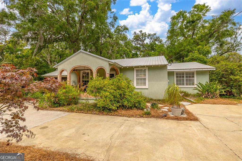 TWO COTTAGES, ENDLESS POSSIBILITIES - ON SAINT SIMONS ISLAND! Welcome to the Cherokee Big House - a dreamy historic beach cottage + a fully functioning guest house that's already a hit on vacation rental sites and a proven money-maker. Whether you're looking for your own coastal getaway, a rental investment, or both - this one's a no-brainer. Originally built in 1943, the main house oozes character and craftsmanship - think heart pine from floor to ceiling (yes, even the roof joists), gleaming oak hardwoods, and a cozy coastal vibe that wraps around you like a sea breeze. The 3 bed, 2 bath charmer has been renovated with an open floor plan, a stylish new kitchen with stainless steel appliances, modern bathrooms, and a newer metal roof + HVAC to keep things cool and carefree. Picture this: You're sipping a cocktail by your custom outdoor fireplace, surrounded by lush fruit trees, with the sounds of the island in the background. Want oysters? Toss them on the grill. Craving peace? Rock your worries away on the covered front porch. There's even a circular driveway, 2-car carport, and room to grow (hello, new pool!). Out back, your guest cottage - affectionately known as the Cherokee House - is turn-key ready for rental income. Built in 2005 with its own private entrance, this 2 bed, 1 bath escape has a kitchenette and plenty of serenity for vacationers or long-term guests. Here's the kicker - this gem sits in an X flood zone, and is flanked by a wooded buffer zone, and you're just a bike ride from the beach, shops, and dining. Plus, you're buying into a transitional neighborhood where renovations are happening all around. Live in one, rent the other - or rent both and ride the appreciation wave. The opportunities here? Limitless. Call today and stake your claim in one of Saint Simons' hottest up-and-coming areas. Own a slice of history and a smart investment all in one.
