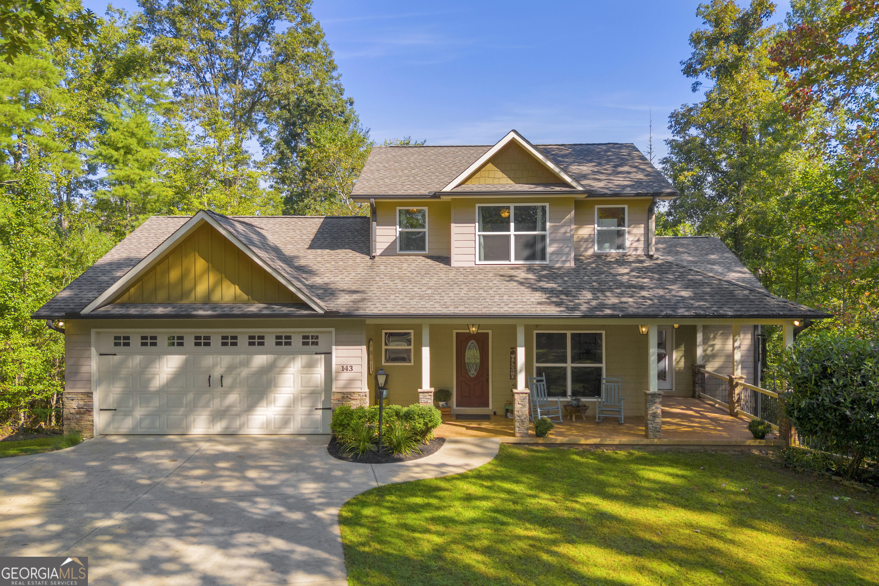 Enjoy the best of both worlds-seasonal mountain views and serene creek frontage! This custom-built craftsman style 4BR/3BA home offers privacy while still being conveniently close to schools, shopping, and everyday amenities. From the moment you arrive, you'll be welcomed by its great curb appeal, beautifully landscaped 1.97-acre setting, and inviting outdoor spaces. Relax or entertain on the wraparound porch, covered back porch, grilling deck, covered patio (perfect for a hot tub), fenced yard, or cozy fire pit. Inside, the main floor features an open layout with hardwood floors, a stone fireplace with built-ins, and a custom kitchen with abundant storage, solid-surface countertops, and stainless-steel appliances. The owner's suite-with private bath and access to the covered porch-plus a second bedroom are also on the main level, along with a large 2-car garage. Upstairs, you'll find two spacious bedrooms, each with walk-in closets, and a full bath. The full unfinished basement, with plenty of natural light and stubbed for an additional bath, offers endless possibilities for expansion. A private trail winds through the property leading to Tesnatee Creek, where you can enjoy nature at its best. Hot tub and furnishings are negotiable-making this home move-in ready and full of opportunity! New roof in 2018 and New HVAC in 2020