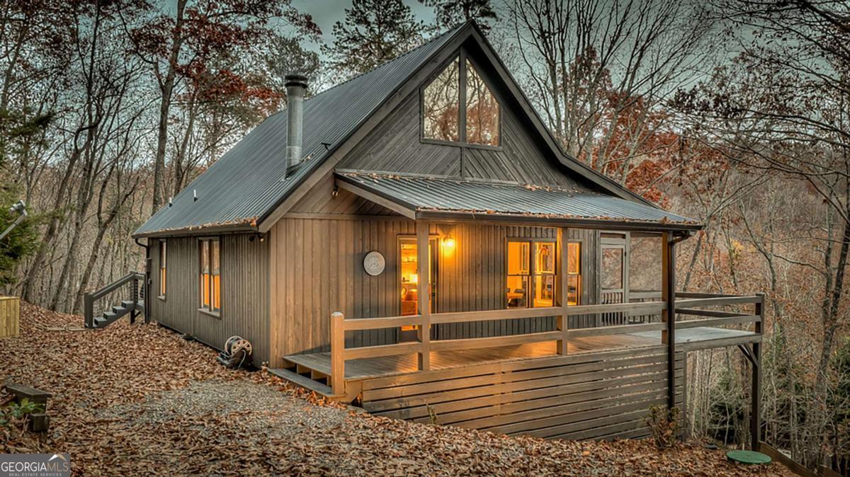 Discover tranquility at Sunrise and Stardust, a distinctive mountain retreat. This cabin serves as a scenic sanctuary, inviting you to start your day surrounded by the breathtaking long range views of the mountains. Expansive views unfold from almost every room while being tucked away from the hustle and bustle, offering a serene escape for an authentic connection with nature. Whether indoors or on the porches, the incomparable views become a part of your daily experience. Step inside to authentic tongue and groove details and hardwood floors throughout alongside modern renovations, executed with precision, to preserve the very essence of the cabin. This two bedroom, two bathroom cabin is offered fully furnished with stainless steel appliances, custom stone countertops, vaulted ceilings and a wood burning fireplace. Sitting on a double lot for added privacy, don't miss the chance to own this incredible investment opportunity.