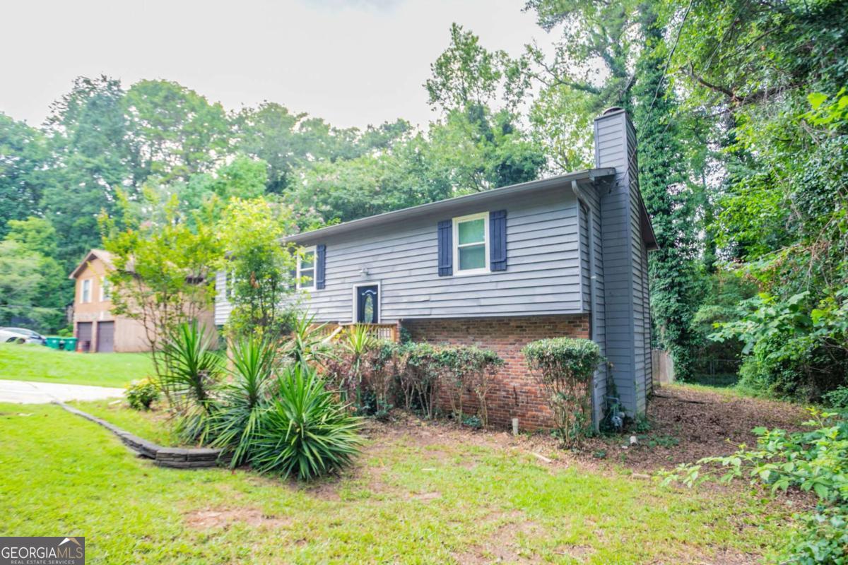 Charming and spacious, this 4-bedroom, 3-bath split-level home offers flexible living across multiple finished levels. The main floor features a country-style kitchen that flows into a cozy gathering room with tile flooring and a fireplace. The upper level includes three nicely updated bedrooms and two full baths, while the finished lower level provides a private fourth bedroom and full bath-ideal for guests, a home office, or in-law suite. Enjoy gatherings on the back deck overlooking the large, level backyard. With hardwood floors, a two-car garage, and walk-in closets, this well-maintained home is located in a quiet, established neighborhood close to schools, shopping, and major roadways. A wonderful blend of space, comfort, and location!