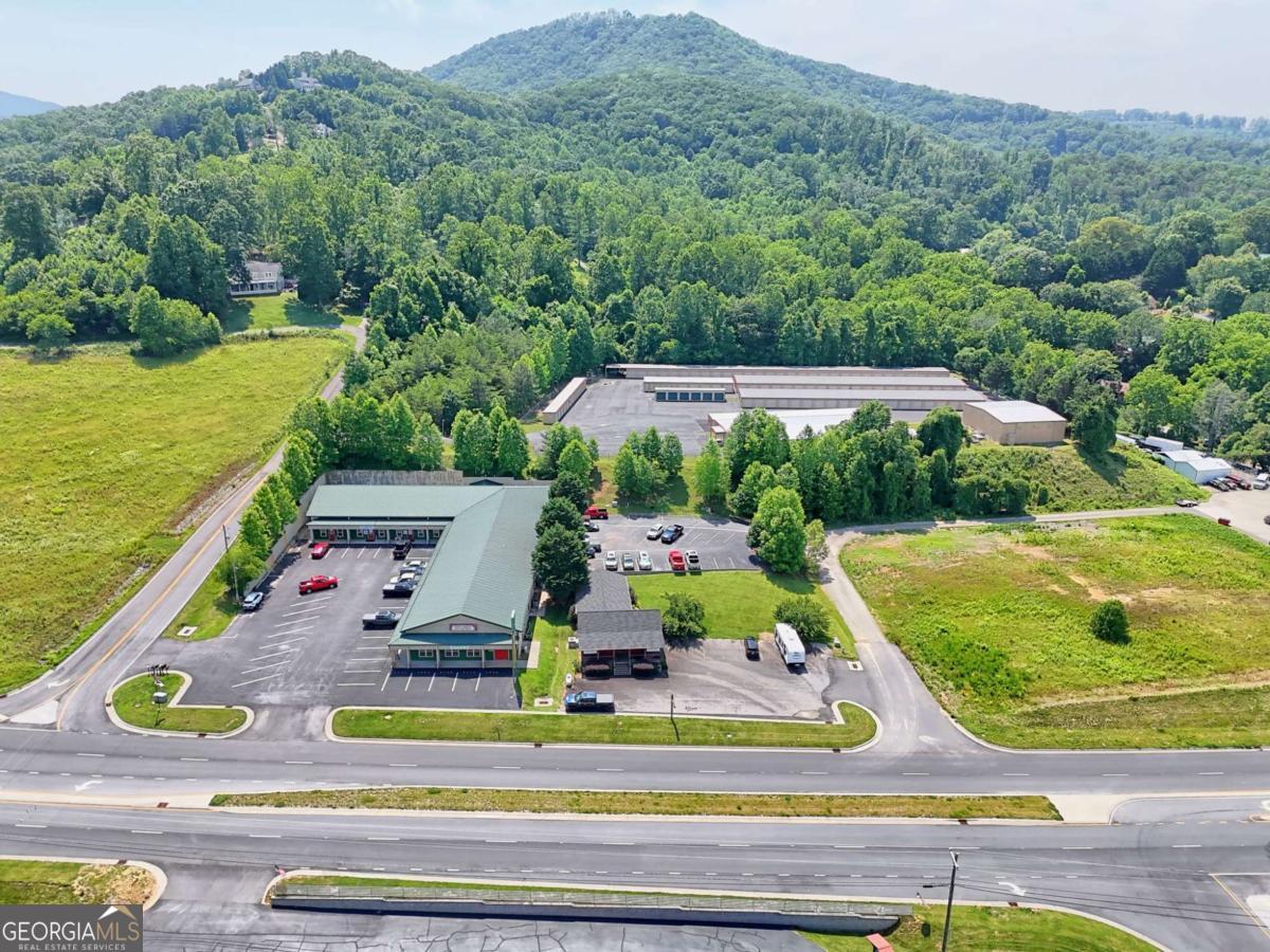 20,654 sf office building on 1.492 acres with excellent frontage along Highway 69 leading from Hayesville to Hiawassee offering good visibility and access. Prominent sign for tenants to advertise. 53 parking spaces (front & rear areas) are provided for tenants and visitors. Office improvements include solid wood crown molding, windows to the hallways, insulated walls between spaces, solid core doors, finished ceilings, ceiling fans and canned lights. Well-appointed kitchens and kitchenettes in each space. BRMEMC Fiber Internet provided to all tenants as well as water and sewer. Property is serviced by a private well and septic system. County water and sewer available at the road - current owner never connected. Rent roll, property layout and unit mix available upon request. Exterior painted twice, septic serviced 2025.