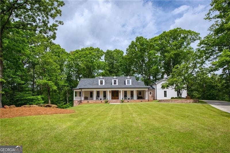 Nestled in the heart of Milton, Georgia, just three miles from the vibrant downtown Alpharetta, this stunning custom farmhouse is a true masterpiece. Situated on a private, expansive two-acre lot, this builder's own home blends timeless craftsmanship with modern luxury. Boasting five spacious bedrooms and five and a half beautifully appointed bathrooms, this residence is designed for comfort and sophistication. The main level features a serene master retreat, while an additional master suite above the garage offers privacy and versatility. Throughout the home, heart of pine floors exude warmth and character. Entertain effortlessly in the chef's kitchen, complete with top-of-the-line Wolf and Sub-Zero appliances, perfect for culinary enthusiasts. The finished basement adds even more space for recreation, relaxation, or hosting guests. Step outside to the breathtaking covered porch, where a striking craftsman-style stone fireplace sets the stage for cozy evenings. Whether you're sipping morning coffee or enjoying an alfresco dinner, this inviting outdoor space is a dream. The charming rocking chair front porch, adorned with an elegant brick herringbone pattern, offers a warm and welcoming entrance, perfect for peaceful afternoons spent enjoying the scenery. Luxury, privacy, and timeless charm-this Milton farmhouse is more than a home; it's an experience. Don't miss the chance to make it yours!