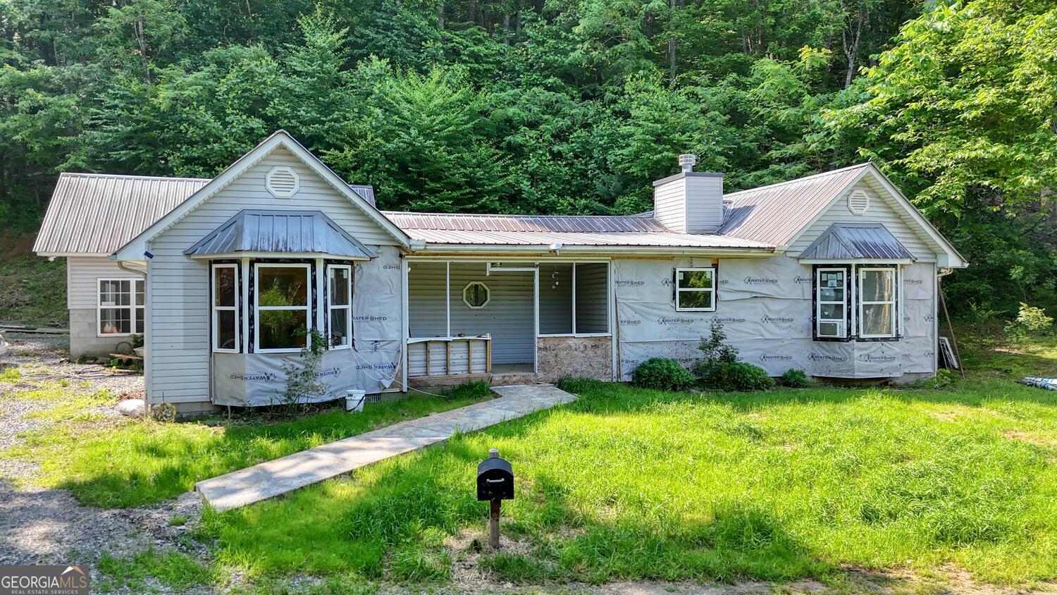 This 3 Bedroom 2 Bath ranch style home is an excellent home to live in while finishing some of the upgrades the owner has started. Many upgrades have already been done. Beautiful new Cabin style living room with all wood walls, ceiling, flooring and gas fireplace. Kitchen has oak cabinetry with new appliances. Dining room has a vented fire place. 2 bedrooms has new paint and flooring. Master bedroom is all new. Big enough for sitting area and a 128 sq. ft. walk in closet has been added. Upgrades were in progress that need finishing in Master. New items done to the house Septic, windows, side walk, heating and air, ductwork, LVP flooring in most of the house, Fireplace, appliances, electrical panel, 30 amp in garage. Every mans dream a Gun Volt Room. Very little to be done to make this your dream home. The roof is metal, siding is Vinyl, level to gentle laying lot within minutes to Hiawassee, School, lake, restaurants and shopping.