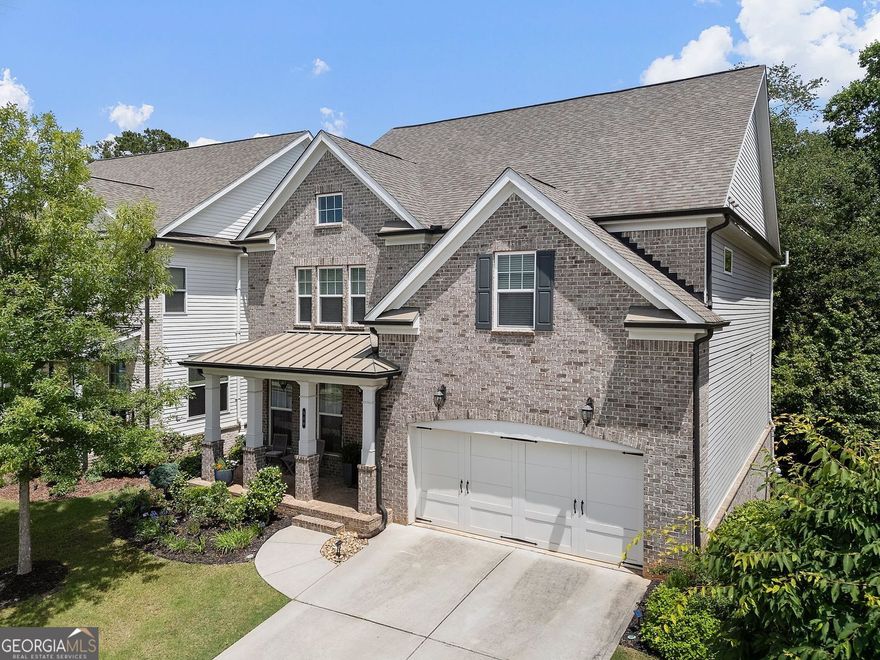 Set within a gated community in one of North Fulton's most convenient locations, this home offers a balance of thoughtful design, everyday comfort, and access to top-rated schools. A guest suite on the main level includes a private bath, creating flexibility for guests or day-to-day living. The heart of the home is the spacious kitchen-complete with quartz countertops, double ovens, a central island, and an everyday dining area that opens to the wooded back yard and deck. The home is located within the Alpharetta city limits and benefits from Forsyth County taxes.  The soaring ceilings in the two-story living room bring in natural light, while the hardwood floors add warmth and continuity throughout the main level. Upstairs, the primary suite features a spa-style bath with a soaking tub and separate shower, along with a custom-designed walk-in closet that feels straight out of a magazine. A loft area upstairs offers space for a library, home office, or quiet retreat.  The unfinished basement-a rare feature in this neighborhood-offers potential for future expansion. A covered front porch adds charm, and the community includes swim and tennis amenities. With close proximity to Avalon, Halcyon, and GA-400, this home delivers both function and flexibility in a location that rarely compromises.