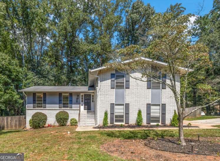 GORGEOUS 4 Level, 5 bed/ 3 bath Home with Chef's Kitchen & Designer Finishes in Atlanta GA! Stunning chef's kitchen, featuring a 48" 8-burner gas range with industrial hood, pot filler, oversized 8' island with black leathered quartz, built-in beverage station with wine fridge and an 11' vaulted walk-in pantry. Quartz counters and backsplash extend to the ceiling for a sleek finish! Serene primary suite boasts 11' vaulted ceilings, spa-like owners bath with double vanity, LED mirrors, walk-in shower, smart toilet, W/D hook-ups and an oversized two-sided closet with built-ins! both upstair secondary bedrooms feature vaulted ceilings, custom bookcases and ample storage. The spacious living room offers a fireplace, built-ins, a stylish bar with storage & lighting, and a secret door to the lower level- perfect for an added sense of privacy, secure spaces, or a fun surprise for guests! The fully finished lower level offers two additional bedrooms, a full bath, gym/flex space, laundry and barn doors for added style. This home is complete with refinished hardwood floors on upper levels & LVP on lower, adjustable can lights, new fans, abundant built-ins, and thoughtful upgrades . Enjoy the fully fenced backyard with multiple outdoor areas designed for both relaxation and entertaining. A two-level deck & private patio located beneath the kitchen deck - a perfect shaded retreat. New furnace & termite warranty in 2023. Move-in ready and FULL of high-end touches. NO HOA. Welcome Home!