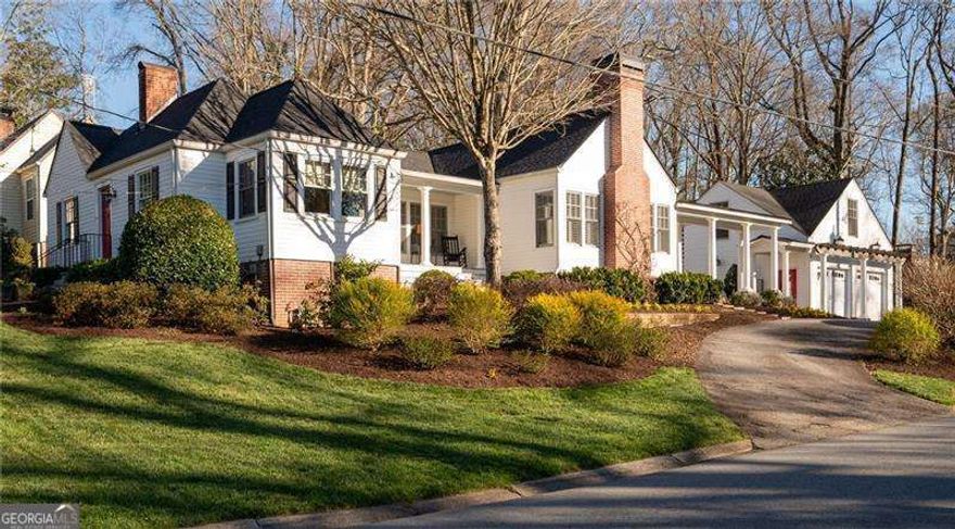 Featured in the book "Marietta - The Gem City of Georgia" as well as having been on the Tour of Homes, this well appointed GEM on Maple Ave is quite the catch!  More recently this house has become known for its beautiful landscape that could easily win Yard of The Month every month! With the pristine landscape, beautiful addition and upgrades including the stately colonnade to the carriage house w/ 2 car garage, this home is quite the showstopper on one of Marietta's most beloved streets. Inside is just as spectacular with historical details paired perfectly with updated open living. This 3 bedroom 3 bath home (2 bed/2 bath in the almost 2K sq ft main house with another 600 sq ft 3rd bed and bath, in the carriage house) has been meticulously maintained! From the circular drive you will find the back porch entrance overlooking a stunning terrace with a beautiful brick fireplace. Step inside this amazing home and see the spacious family room with vaulted ceilings with wainscoting & the 2nd of 3 fireplaces. 2 lovely built-in bench seats flank the fireplace giving you a perfect spot to curl up with a good book. The family room is open to the kitchen separated slightly by 2 more beautiful columns and clever architectural details that make this home such a unique and stylish space. The custom built island is the heart of this kitchen w/ glass front cabinets, fabulous molding & lighting inside   as well as under the cabinets. Dining room has built-in bench seating & recessed cabinetry that is a beautiful reminder of the great history of the home and the details of that era.  There is also a side porch, the perfect spot to sit and enjoy sunset. Wandering on to the front of the home you will find the formal living room w/ 3rd fireplace & gas logs as well as a built-in bookcase leading to cheery office w/ so many windows, built-in desk & beautiful wood paneling.  The primary suite is on the back of the home giving you great privacy, w/ french doors that lead out onto the back porch overlooking the terrace. Private bathroom w/ custom cabinets that will give you a place for everything along w/ a walk in closet. 2nd bedroom on the front of the home adjacent to hall bath which features walk-in shower all updated in classic tiles that will never go out of style! A back hall connects both bedrooms to the laundry room and additional closet space as well as a built-in pantry.  Beautifully restored hardwood floors & plantation shutters throughout the main house show how no detail has been overlooked. Just steps from the back porch is the most amazing terrace w/ fireplace and even a second patio area with a large brick outdoor kitchen complete with a gas grill and sink.  The mixture of bricks and natural stones give such a warmth and nod to timely elegance rarely found these days.  You can access the carriage house from the back terrace or with just a few steps through the colonnade that takes you into the garage and to the staircase leading you to the 3rd bedroom and private bath with great storage. This could be a perfect STR. Garage has room for 2 cars as well as work space. This house is a must see and you will not believe the yard come spring when everything start to bloom. Lots of great flowering bushes make it easy to maintain. So much love and care has been put into this yard, including a sprinkler system. The main house also features a fire sprinkler system, brand new roof, and exterior paint.  HVAC and water heaters have been replaced in the last few years so nothing to worry about in this lovely home.  Now let's talk about the location!!  Maple Ave is sought after for many reasons, top schools being one, but the holiday orbs turn this street into a winter wonderland.  The Halloween parade is a must see! A short stroll to the Marietta Square w/ the fun concerts, festivals, amazing restaurants and shopping.  The MTR trail & the Kennesaw Mt Nat'l Park all right in the area. It really doesn't get any better than 255 Maple Ave!