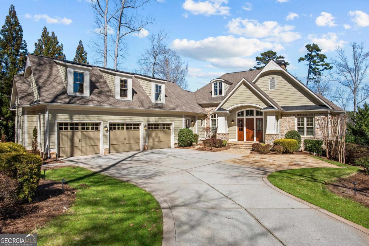 QUALITY, CRAFTSMANSHIP, VIEWS, LOCATION! This stunning custom lakefront estate at Sandy Ford in Reynolds Lake Oconee, designed for luxury and comfort, was crafted by reknowned builder Jim Joel and offers panoramic lake views and unparalleled location minutes from the Ritz and Lakeclub by boat. Every detail of this home reflects superior quality craftsmanship, from intricate trim work to masterfully designed stone accents. Barrel ceilings, wood beams, add touches of architectural elegance, enhancing the grandeur of the spaces. The great room immediately captivates with expansive windows showcasing the lake, fireplace, and a stylish wet bar, creating the perfect setting for entertaining. The formal dining area is ideal for gatherings, while the chef's kitchen boasts a large island, high-end appliances, and custom cabinetry. A stunning keeping room with thoughtfully-curated finishes create an atmosphere of refined luxury with incredible lake views providing a peaceful retreat. Additional features on the main level include a private office space, spacious laundry room, grill deck and gorgeous half bath. Step outside to an expansive covered stone porch, where breathtaking lake views create the perfect space for relaxation.The primary suite is a private oasis with a custom ceiling and serene lake to wake up to every morning. Its spa-inspired bath features a soaking tub, oversized shower, and his-and-her closets, ensuring the ultimate retreat. Above the three-car garage is a spacious bonus room/guest suite with a full bath offers versatility for guests or extended stays. Descend to the terrace level via the grand spiral staircase or elevator, and you will be impressed with the spacious family room featuring a stunning bar with intricate details, a fireplace and temperature-controlled wine cellar. This seamlessly flows to the resort-style backyard where a pool, hot tub and expansive stone patios create an idyllic retreat. You will enjoy lounging by the outdoor fireplace, unwind by the serene pond, or take a boat ride from your private dock. Whether it's a sunset cruise, a day of lake recreation with children or grandkids, or a short boat ride to the Ritz or Lake Club for lunch, this home offers unmatched access to Lake Oconee's best experiences. Three spacious guest suites, each with a private bath, ensure comfort for visitors. With breathtaking views and top-tier amenities, this property is truly a lakefront paradise. Membership to Reynolds club is available.