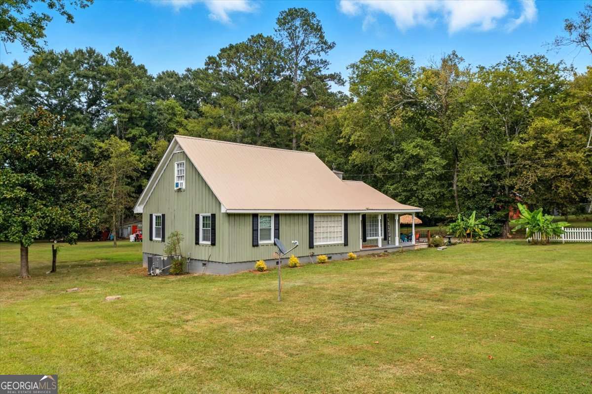 You have to check out this charming home right in the heart of Plainville! This gem offers plenty of room with four bedrooms, separate dining room, oversized laundry room, cozy foyer/den and eat-in kitchen! Gleaming hardwoods throughout! Rough sawn lumber siding and metal roof. Accessible ramps at front and back doors. Situated on a level 1+ acre lot with a 575 sf storage building and double carport! Set up your showing today!