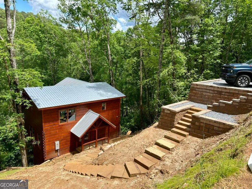 A walk-in storage space can be found under the back deck with its own patio and entry door as well as a cleared trail through the back yard leading straight to the creek. So much potential for this property! As part of The Preserve at Mountaintown Creek, residents enjoy access to amenities including a pool, pickleball courts, and pavilion. Whether you're looking for a primary residence, place to retire, weekend getaway, or an investment property, this beautiful one of a kind log cabin is an opportunity you won't want to miss!