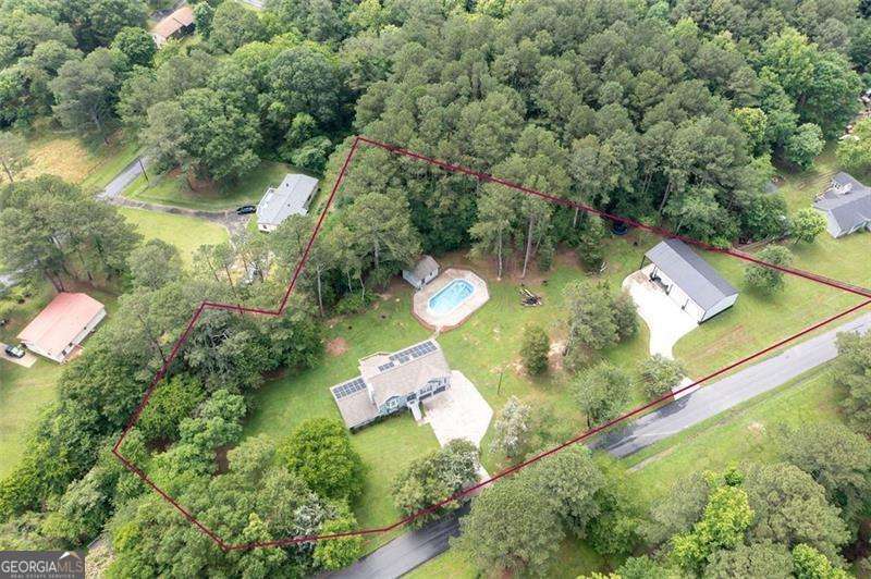 No HOA - Just Freedom, Space & Style! Welcome to your dream retreat on 1.92 acres of peaceful country living-with no HOA restrictions! This beautifully updated home offers modern comfort, flexible living, and endless possibilities for work, play, or multi-generational living. Inside, you'll find two stunning kitchens, both fully renovated with shaker-style cabinets, soft-close drawers, and stainless steel appliances. The main kitchen also features a reverse osmosis system for pure, clean water. Updates throughout include new flooring, baths, and mechanicals-all within the last 5 years! Multi-Generational Living Made Easy- This home features TWO luxurious primary suites, ideal for in-laws, teens, or guests. The lower level offers a private entrance, full kitchen, suite, flex room, and two additional full baths-a true in-law or teen suite that lives like a second home! A Workshop Like No Other- Calling all car lovers, woodworkers, hobbyists and entrepreneurs-this 1,600 sq ft detached workshop is a rare find. Built with 4000 psi commercial-grade concrete (8" footers, 6" slab), it features: Three 14x14 insulated bay doors 16'+ insulated walls Wood-burning stove Private driveway access 12' covered patio-perfect for relaxing after a day's work Whether you're building cars, or just need serious space for all of your "toys", this shop is a game-changer! Outdoor Living + Energy Efficiency- Relax on the spacious deck overlooking your 18x36 splash pool (with new liner) and pool cabana ready for your finishing touches. Solar panels and a Generac backup battery slash utility bills and offer peace of mind during outages. Minutes from I-75, downtown Cartersville, Tellus Museum, Savoy Auto Museum, and the upcoming Rome-Cartersville Development Corridor, this home offers country privacy with city convenience. Come see it in person-this one truly has it all!