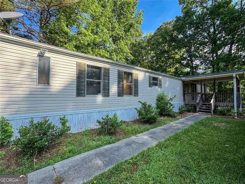 LOCATION, LOCATION, LOCATION!!! Investor special or perfect starter home with fix and flip potential! Located in desirable Acworth, GA, just minutes from Lake Allatoona, I-75, and LakePoint Sports Complex, this 3 bedroom, 2 bathroom mobile home sits on a peaceful half-acre lot-ideal for those seeking rental income or an affordable primary residence. With 1,064 sqft of living space, this home is set on a permanent foundation, making it eligible for traditional financing. Recent updates include brand new plumbing, only 7 year old metal roof, and a spacious covered front porch offers charm and outdoor living appeal. The property includes three outbuildings-perfect for storage, a workshop, or future expansion. While it needs a little TLC, the strong bones and unbeatable location make this a prime opportunity for real estate investors, first-time buyers, or anyone looking for an affordable home in a high-demand area. Don't miss out on this value-packed property with endless potential! Property being sold AS-IS. CASH ONLY!