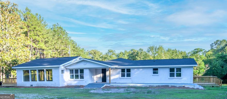 This is a jaw dropper.  This home sits on 3.67 acres and is completely remodeled.   It has foam sprayed insulation in the walls and ceilings. Three bedrooms, one of which is approximately 800 square feet and could be used as a family room, surrounded by large double paned windows offering so much natural light , & a large walk in closet. Each of the 3 bedrooms have their own private exterior entrances and 2 bed rooms of which have wooden decks. This home has 3 full baths, one has a double vanity.  The breakfast room could easily be used as an office if you wish with all the natural light.  The kitchen has all new stainless steel appliances and a pantry.  There are fruit trees that includes scuppernongs, figs, pears and plums. A must see.