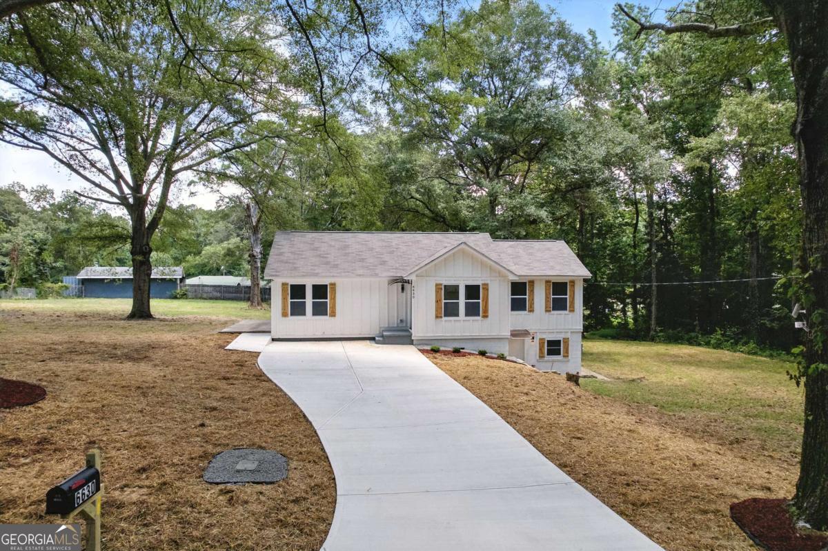 Welcome to Your Dream Home at 6630 Lucile Ave From the moment you turn onto the quiet, tree-lined street of Lucile Avenue, a sense of peace welcomes you home. Nestled among towering trees and resting on a spacious lot, this fully renovated modern farmhouse is more than a house - it's a feeling. As you step up the wide, welcoming front steps, you can already imagine sipping morning coffee on the porch while the Georgia sun filters through the leaves above. Open the front door, and you're greeted by an open-concept layout flooded with natural light, stylish finishes, and thoughtful details that balance elegance with comfort. The heart of the home - the gourmet kitchen - will leave you breathless. Featuring a statement waterfall island with warm wood accents, sleek quartz counters, modern pendant lighting, and white shaker cabinets, this space is built for both functionality and style. Whether it's breakfast with the kids or hosting wine nights with friends, this kitchen adapts to your lifestyle beautifully. Flow effortlessly into the cozy living space, where warm-toned LVP flooring runs underfoot, and every element is designed to invite connection, conversation, and calm. The bathrooms are spa-worthy - decked in stunning marble-style tile, matte black fixtures, and double vanities that blend form with function. Each bedroom offers a retreat-like escape, with natural views, modern finishes, and ample closet space. The split-bedroom layout offers privacy for guests or family members, while the finished basement opens up endless possibilities - home office, game room, or even an in-law suite. Step outside and feel the magic of this private, wooded lot. There's room to garden, entertain, or just breathe in the fresh air. And with a long, curved driveway, there's space for guests to visit and stay a while. Living in Lithia Springs means more than just owning a beautiful home. You're minutes from Sweetwater Creek State Park, where weekends are for hiking, kayaking, or picnicking by the water. Enjoy local breweries, quaint shops, and charming eateries just a short drive away. Downtown Atlanta is close enough for a quick commute, yet far enough to keep your evenings quiet and peaceful. This isn't just a home - it's the life you've been searching for.