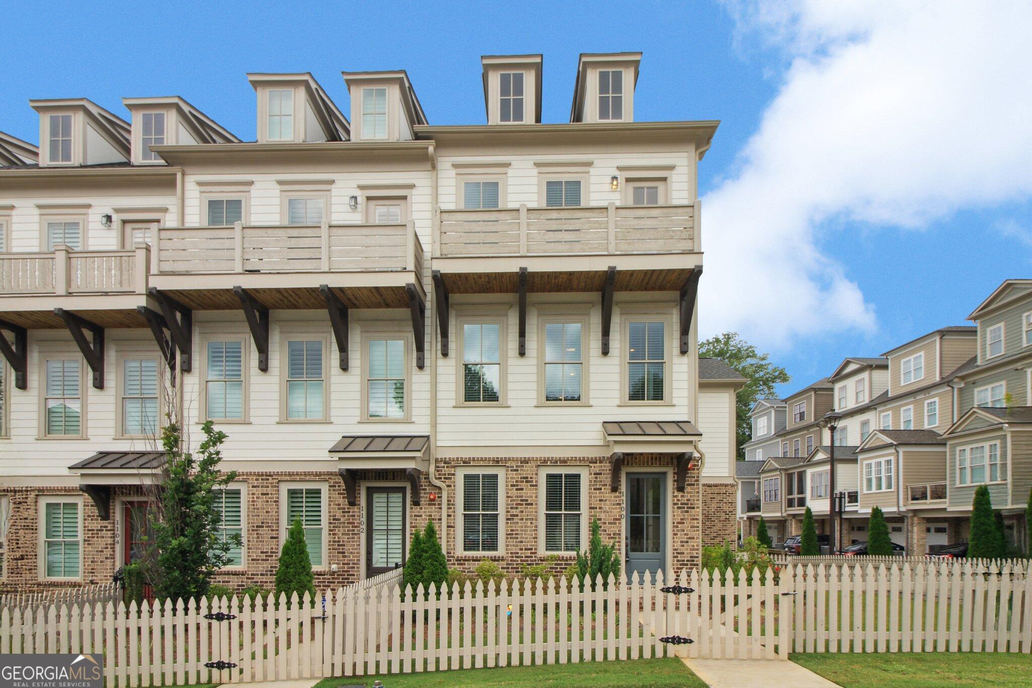 Just a 5 minute walk from Downtown Woodstock, this beautiful end unit 3 bedroom, 3.5 bath townhome is packed with natural light and thoughtful upgrades, including a side addition with a keeping room and a rare 3 car garage! With 3 large bedrooms and 3.5 bathrooms, this home stuns with gorgeous wide plank white oak hardwood flooring throughout - there is zero carpet or LVP in this home! The gourmet kitchen is well appointed with all stainless steel appliances, custom cabinetry, and a counter-to-ceiling herringbone tile backsplash. The open-concept main level flows from the kitchen to a large, light filled family room with an elegant slate fireplace and built-in bookshelves. Upstairs, the master bedroom features a full length balcony and a large en-suite with beautiful black granite double vanities, a large custom tile shower, and a spacious walk in closet. This home also contains an attic that is ready to be finished into a large 4th bedroom or used as is for storage. Enjoy all the amenities South on Main has to offer including a large clubhouse and fitness area, pool, dog parks, playground, and miles of paths and direct access to the Noonday Creek Trail. Enjoy maintenance free living just minutes from Downtown Woodstock as grounds-keeping, exterior maintenance, and home insurance are taken care of by the HOA! =