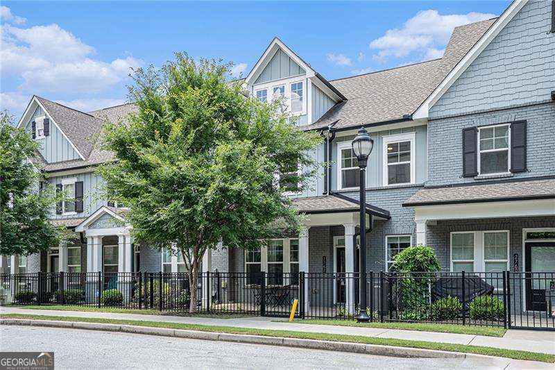 This beautifully appointed two-story townhome, crafted by David Weekley Homes, offers timeless elegance with a modern twist. As one of the original Alderberry floor plans, it captures a warm, cottage-inspired feel while delivering space and style. Step inside to an inviting open-concept layout-ideal for both everyday living and effortless entertaining. The designer kitchen is the true centerpiece, featuring soft dove-gray cabinetry, white and gray marbled quartz countertops, and an oversized island that invites conversation and connection. The adjoining living and dining areas are filled with natural light and flow seamlessly for relaxed gatherings. Upstairs, the spacious primary suite is a true retreat. Enjoy a spa-like ensuite bath complete with a generous super shower, waterfall showerhead, and built-in bench seating-your own private escape at the end of the day. Two additional bedrooms and a well-appointed full bath round out the upper level, offering plenty of space for guests, a home office, or a cozy media room. Enjoy the convenience of low-maintenance living in a vibrant location just minutes from The Battery Atlanta and Truist Park-home of the Atlanta Braves-with access to premier dining, shopping, and entertainment right at your doorstep. Experience a lifestyle of comfort, style, and unbeatable convenience. Schedule your private showing today.