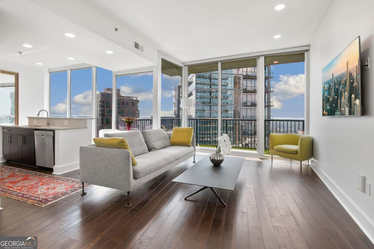 Experience iconic Midtown living at its finest at 1010 Midtown. Perched high on the 29th floor, this residence showcases the building's most sought-after one bedroom floor plan. Its expansive, corner-wrapped balcony, finished with green turf, offers breathtaking 270 degree views, overlooking Peachtree Street all the way to Downtown, including the Mercedes Benz Stadium and Tech Square, accumulating in Western horizon sunsets. A 10 ft floor to-ceiling window front spanning the living, dining, and kitchen areas flood the home with abundant natural light, highlighting the open and inviting layout. Chestnut hardwood floors flow seamlessly throughout and pair beautifully with the cabinetry, granite countertops, and premium Bosch stainless steel appliances. A surprising amount of storage includes a walk-in master closet, additional hallway linen/coat closet, and large kitchen pantry. This home features recent upgrades such as a HVAC system/water heater as well as a brand new full size washer/dryer. All ceiling can-lights and light fixtures are replaced with dimmable LED lighting sitting flush in the ceiling, elevating the room height even further. Together with the sleek wall-mounted TVs in the living and bedroom area they create a modern contemporary feel. Residents of 1010 Midtown enjoy unparalleled amenities, including 24-hour concierge service, a state-of-the-art fitness center (one of the best in the city), and the largest residential sky park in Midtown, including large saltwater pool, outdoor kitchen, numerous grill and entertainment areas, and open fire pit and fountain, all on the 8th floor amenity deck with sweeping midtown views. One deeded parking space in the secured residential garage adds convenience to this exceptional home. Situated in the heart of Midtown's vibrant art and cultural corridor, you'll be just steps from Piedmont Park, the Beltline, Atlanta Botanical Gardens, the High Museum and Atlanta Symphonie, Whole Foods, premier dining and entertainment, and the city's most dynamic business hubs. Bask in sunlight and skyline views by day; by night, let the glittering city lights create the ultimate backdrop for entertaining or unwinding. Come and see for yourself what life on "The Curve" offers you.