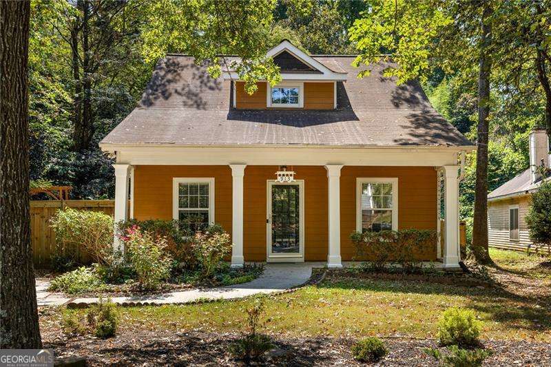 This beloved Ormewood Park bungalow blends timeless character with modern sophistication, all just steps from the Southside BeltLine Trail. The orange house on the bend of Ormewood Avenue has long been a sanctuary in the city, framed by a lush landscaped front yard and a wide porch made for morning coffee, evening wine, and neighborly hellos. Inside, sunlight pours across original hardwood floors, while fresh paint and thoughtful updates elevate every space. The open-concept main level is anchored by a cozy fireplace and designed for connection, whether you are hosting a stylish Friendsgiving, a candlelit dinner party, or simply cooking in the kitchen while chatting over the built-in bar. The kitchen itself balances form and function with stainless appliances, a gas range, and a discreet laundry nook that keeps the focus on entertaining. Two main-level bedrooms and an updated hall bath offer flexibility for guests or a home office with peaceful views of the back and side yards. Upstairs, the private primary suite feels like a boutique hotel escape, complete with a spa-inspired bath, oversized walk-in closet, and even a built-in wood beam bookshelf that invites you to curl up with a good read. Out back, the freshly painted multi-level deck overlooks a private yard that has been thoughtfully expanded and landscaped into its own retreat. Raised garden beds, berry bushes, blooming hydrangeas, roses, azaleas, and a sprawling magnolia tree attract owls and other visitors, making it feel like your very own wildlife sanctuary in the heart of the city. It is the perfect backdrop for grilling, al fresco dinners, cocktails under the stars, or long fall afternoons. The location is equally special, with wide, tree-lined streets, generous sidewalks, and bike lanes that take you to the BeltLine, Red's Farm, Grant Park, the zoo, and Glenwood Park within minutes. Zoned for Parkside Elementary and Tier One for Atlanta Neighborhood Charter School, this home pairs the energy of intown living with the comfort of a true Southern cottage.