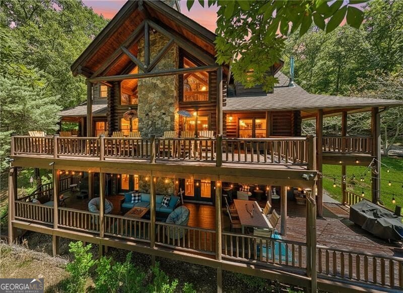 Escape to your own private mountain estate-an exceptional gated retreat on 11+ acres of unspoiled natural beauty centrally located just minutes from downtown Blue Ridge, McCaysville and Copper Hill. This furnished, resort-style compound offers 6 bedrooms and 7 bathrooms across a custom log chalet and separate Guest House, ideal for multi-generational living, airbnb opportunity or your private getaway. With gated entry, enjoy complete seclusion at the end of a winding quarter-mile driveway, surrounded by wildlife, fruit trees, and native forest with your own adventure trails for hiking, biking, and ATV riding. The main home features soaring ceilings, a chef's kitchen with granite counters and seating for 12, home theater, gym, steam sauna, game room, safe room, and smart-home systems throughout. Entertain year-round on the wraparound porches, lower deck with hot tub, and multiple fire pits. A spring-fed pond is stocked and ready for fishing, paddle boating, or relaxing by the LED-lit fountain. The guest house offers 2 bedrooms, full kitchen, screened porch, and garage parking. Minutes to dining, golf at Old Toccoa Farm, shopping, lakes, and outdoor recreation, yet a world away from it all!