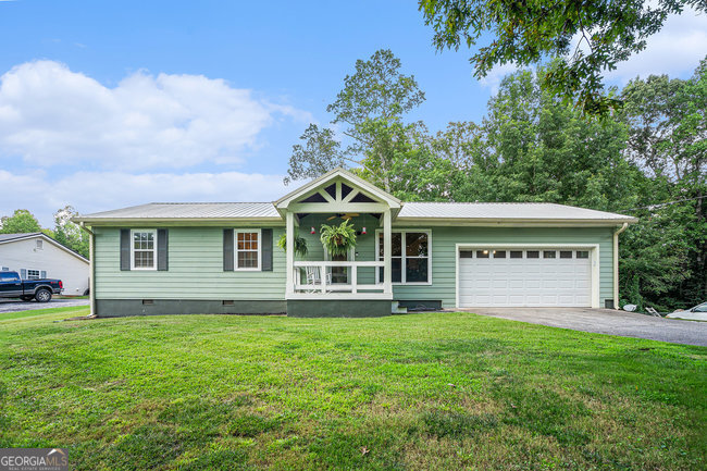 Welcome home to this beautiful well cared for 3 bed, 2 bath ranch on a huge 1.3 acre lot! This peaceful oasis has plenty of natural lighting, bright and open concept living room and dining area which is great for entertaining. The master bedroom boasts an en-suite bath and walk in closet as well as a sliding screen door with backyard access. The additional 2 rooms are large enough to comfortably fit a double bed with additional dressers and furniture. Make no mistake this home is cozy and has a well thought out floor plan for easy access and cleaning. The backyard is fully fenced in with an above ground pool for those hot Georgia summers and also comes with a shed for additional storage. Off the kitchen is a 2 car garage with plenty of space for additional storage. This home has it all and needs nothing just move in and relax!