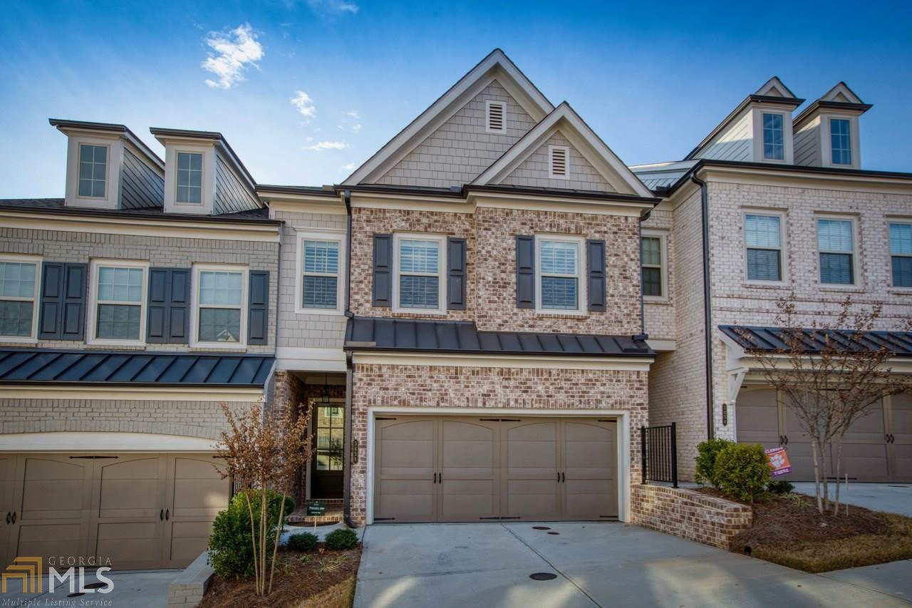 Picture Perfect! This is for the buyer searching for a refined, modern home in the heart of Smyrna! Enjoy entertaining friends in an open floorplan with exposed brick feature wall, hardwood floors, shutters, upgraded lighting, built-in speakers, and a stylish kitchen with marble counters that extend over a large island, stainless steel appliances, glazed backsplash, large pantry, and bar with built-ins. Retreat upstairs to a spacious homeowner's suite with an exquisite ensuite bathroom with tile, marble, double vanity, dual rain shower heads, and luxurious soaking tub. Hardwood floors continue up the stairs and into the bedrooms. The private patio and fenced yard are ready for relaxing. You'll love the convenience & easy lifestyle of townhome living - low maintenance and nice amenities, including resort-style pool with patio, grills, and outdoor fireplace, a fenced dog park, and community bike racks. Located in a picturesque, gated community convenient to major thoroughfares, the new SunTrust Park, The Battery and Village for shopping, entertainment, & dining, the Silver Comet Trail, and several parks.