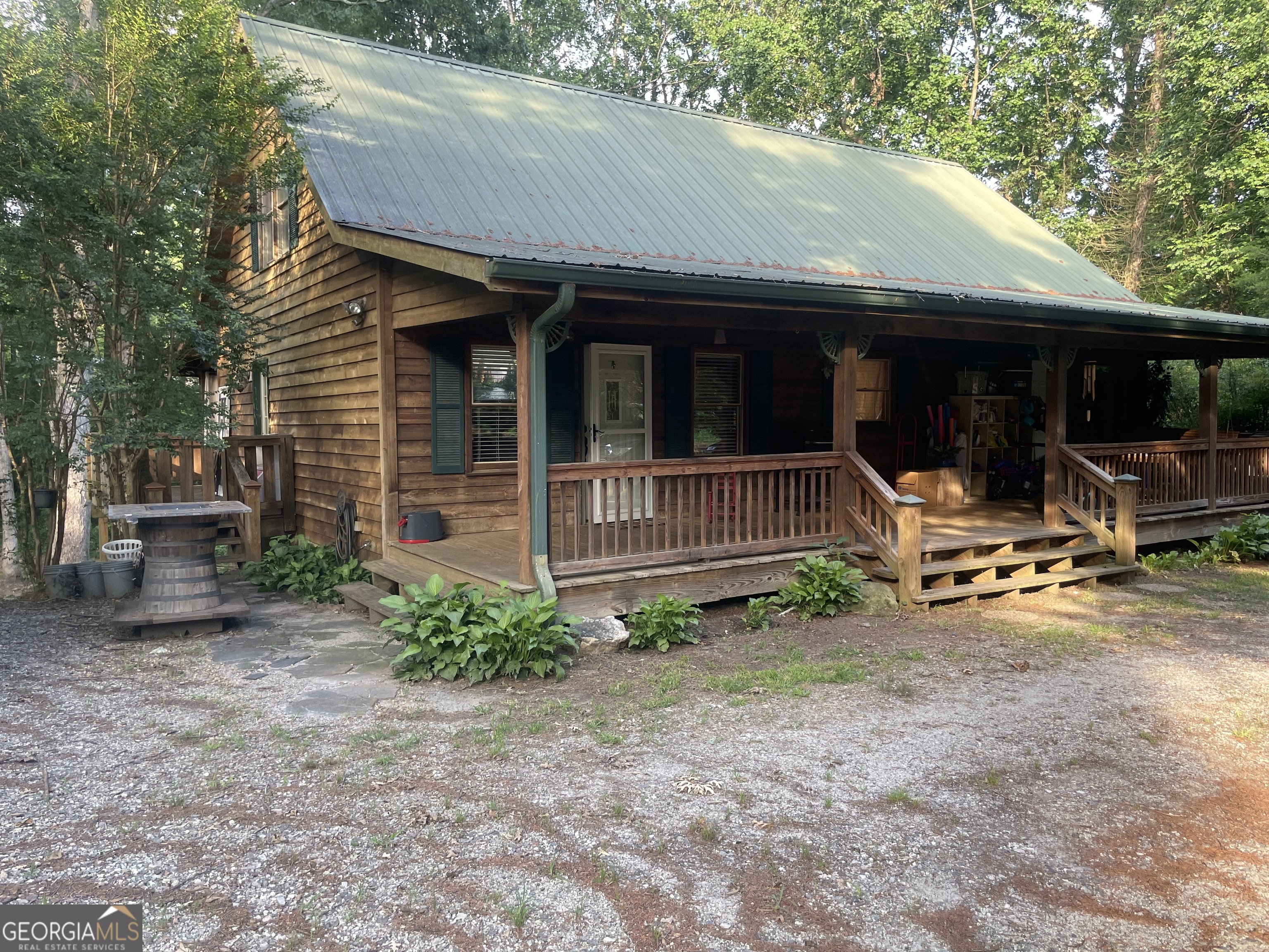 SELLERS ARE MOTIVATED AND HAVE PRICED TO SELL! Beautiful cabin with porches galore! Great location close to schools an shopping! Home has 3 large bedrooms and 2 full baths. Master on main with huge walk-in closet and it's own entrance from porch. Two additional bedrooms upstairs with an additional sitting area/loft. Exterior built with natural wood siding, tin roof (roof screws recently replaced), and lots of covered outdoor seating. Main level has pine flooring throughout and tongue and groove walls. Gorgeous live edge vanity in main bathroom with tile floors. Spacious kitchen with granite countertops, brand new solid surface stove and solid wood cabinets. Farmhouse light fixtures and all the special touches you hope to find in a cabin! Kitchen opens to large dining room and dining area opens onto large covered back porch. Natural wood pickets and handrails showcase the staircase heading upstairs. Back porch is ready for you! Complete with fans, lighting, curtains and wooden swing bed! Porch overlooks open back yard with rock fire pit and play area. Home sits on a full unfinished basement. Basement has regular door heading out to back yard as well as garage door if a shop is desired! So much potential to make it your own! Few additional notes: Main bathroom can be accessed from master bedroom as well as the living room. There are 2 laundry areas. One is in the closet of dining room, another is in the basement if larger laundry is desired.
