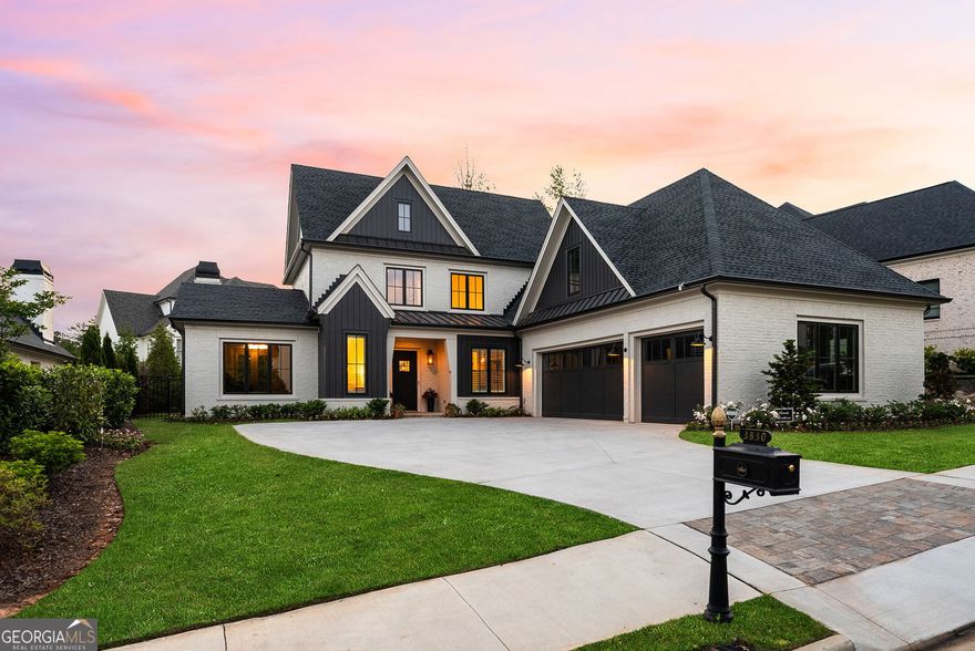 Rare opportunity to own a nearly new custom residence in The Manor Golf & Country Club-located in sought-after Forsyth County, offering lower property taxes without sacrificing the luxury lifestyle. Nestled within the exclusive Manor Cottages enclave, this 2023-built home by Santoro Signature Homes showcases curated designer selections and sophisticated finishes throughout its 4,237 square feet of elegant living space. With 4 bedrooms, 4 full bathrooms, and 1 half bathrooms, this thoughtfully designed floorplan offers a seamless blend of open-concept living and private retreats. The main level boasts a vaulted great room with exposed beams and a striking fireplace, flowing effortlessly onto the covered fireside veranda-perfect for year-round entertaining. A chef's kitchen anchors the heart of the home with top-tier appliances, a service pantry, and an oversized island ideal for gathering. The main-level owner's suite is a peaceful retreat featuring a spa-like bath with a large shower, double vanities, and a spacious walk-in closet with custom built-ins. An elegant study, mudroom, and laundry room complete the main floor. Upstairs, you'll find three spacious en-suite bedrooms plus a versatile media/flex room. Additional highlights include a three-car garage, ample storage, and the refined craftsmanship The Manor is known for. Residents enjoy 24/7 gated security and world-class amenities including indoor and outdoor pools, indoor and outdoor tennis courts, two clubhouses, a Tom Watson-designed 18-hole golf course, fitness center, and walkable sidewalks throughout the community. Conveniently located near top-rated schools, upscale shopping, and just minutes to GA 400. **Seller may consider carrying a small portion of owner financing under competitive terms.**
