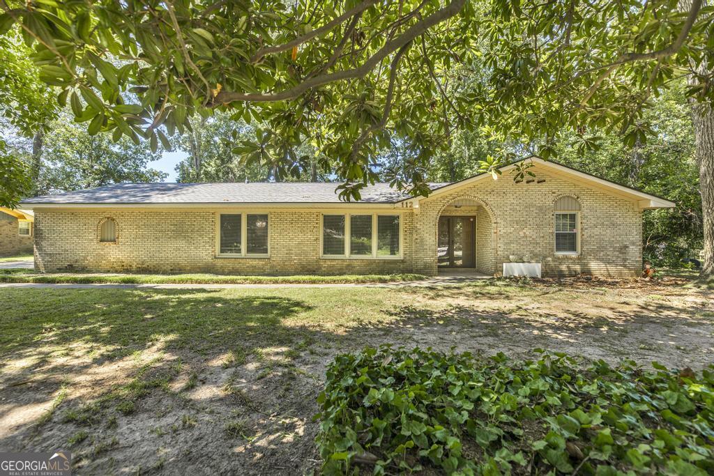 Discover the perfect blend of comfort and convenience in this single-level, four-sided brick home, offered at an incredible price! As you arrive, you'll be greeted by the deep, shady lot and mature landscaping that create a sense of tranquil privacy. Inside, the inviting floor plan unfolds with two separate living spaces, providing plenty of room for entertaining. The main living area features a warm wood-burning fireplace and built-in cabinetry, ideal for displaying treasured mementos. The heart of the home is the updated kitchen, boasting beautiful granite countertops, stainless steel appliances, and a breakfast area where you can start your day with a cup of coffee. The spacious owner's suite provides a peaceful sanctuary, complete with dual closets and a tiled step-in shower. From here, you can step out onto the expansive covered back porch, which is a true outdoor oasis. Overlooking the large, fully fenced backyard, it's the perfect spot for weekend barbecues, a quiet evening, or letting pets run free. Beyond its charming features, this home delivers peace of mind with a new roof (installed just one year ago) and a two-year-old HVAC system. Located in a perfectly convenient Warner Robins location, this opportunity is too good to miss. Schedule your private tour before it's gone!