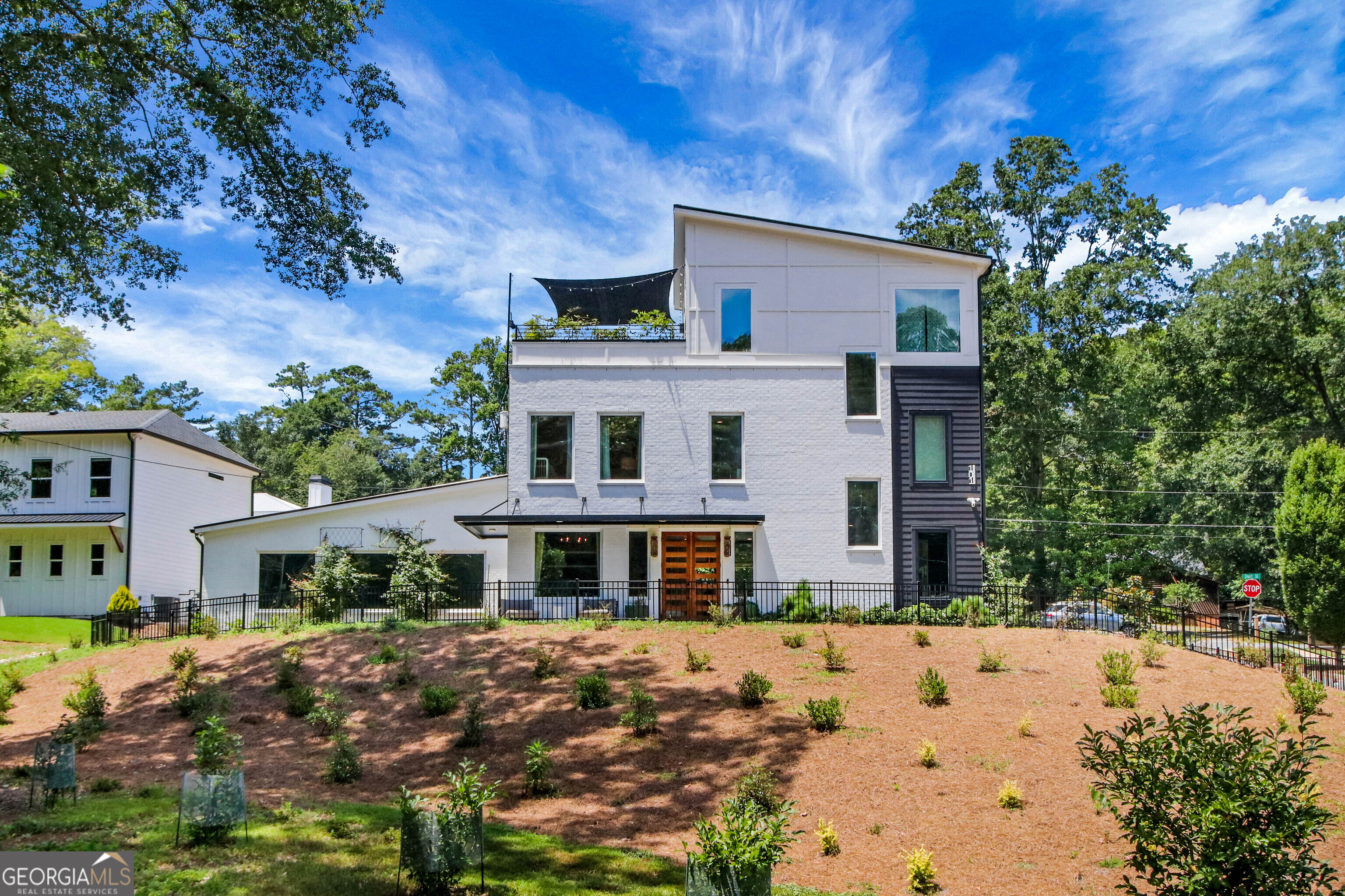 Downtown Woodstock fully custom built home on over half an acre, offering a rare combination of luxury with walkability all the excitement that downtown offers. This one-of-a-kind property features 5 spacious bedrooms, 4 full bathrooms plus a fully equipped pool house with 1 additional bedroom, 1.5 bathrooms, and a game room, perfect for entertaining or extended guest stays. Every detail has been thoughtfully designed, from the designer chef's kitchen with an oversized island and premium appliances, to the elegant mudroom, custom glass privacy garage doors, and open living areas. The primary suite is privately located on its own floor and includes a beautifully designed sun deck, creating a peaceful retreat above it all. Work from home in the dedicated office, stay active in the home gym, and enjoy effortless indoor-outdoor living year-round. The courtyard is your personal resort with a saltwater pool, hot tub, and a fully appointed pool house built for comfort and style. This home is unlike anything else on the market and a true custom home in the heart of Downtown Woodstock, combining timeless design with everyday functionality. Shown by appointment only. POF prior to showing.