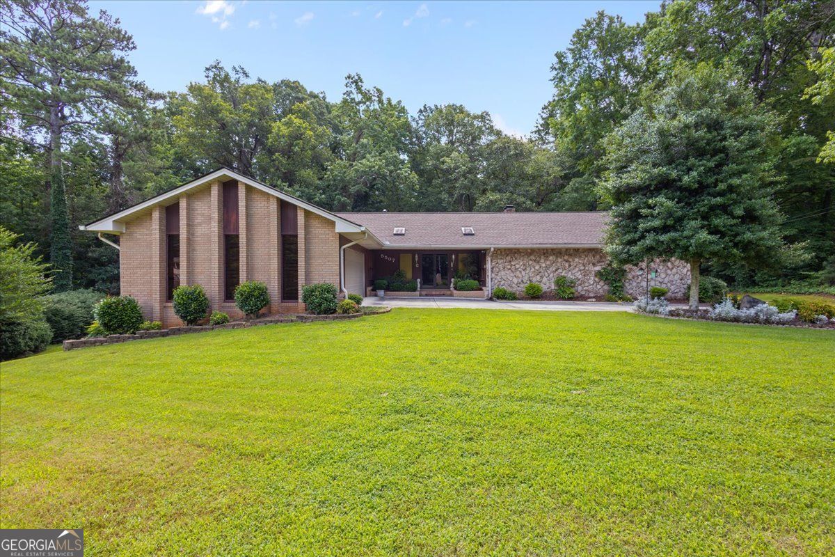 Welcome to 5507 Christi Drive - A Beautifull Retreat in Douglasville*Nestled in a quiet, established neighborhood in Douglas County, 5507 Christi Drive offers over 4,200 square feet of thoughtfully designed living space, perfect for families seeking comfort, space, and convenience. This move-in ready gem blends timeless charm with modern features, all set on a beautifully landscaped lot.*Step into the spacious living room where a soaring vaulted ceiling, elegant crown molding, built-in shelving, and a cozy fireplace create a warm, inviting atmosphere-ideal for both relaxing evenings and entertaining guests.*The kitchen is the heart of the home, featuring a generous island, breakfast bar, sleek stovetop, and classic shaker cabinetry, all accented by refined crown molding. Whether you're hosting friends or enjoying a quiet meal at home, this space is designed to impress.*With four bedrooms and three full bathrooms, there's room for everyone-plus a dedicated laundry room adds to the home's everyday convenience.*Downstairs, the full, finished basement opens up a world of possibilities. This versatile space includes a large bonus room, perfect for a home theater, gym, or guest suite, along with a full bathroom for added flexibility and privacy.*Outside, you'll find a private, fully landscaped backyard oasis-complete with its own second driveway leading to a second garage, ideal for extra storage, a workshop, or parking additional vehicles. The balcony off the main level provides a peaceful view of the surrounding woods, creating a serene backdrop for morning coffee or evening relaxation.*Built in 1974 and lovingly maintained, this home sits on a generous lot and offers a rare combination of space, function, and curb appeal. With its versatile layout and serene setting, 5507 Christi Drive is more than just a home-it's a place to create lasting memories.