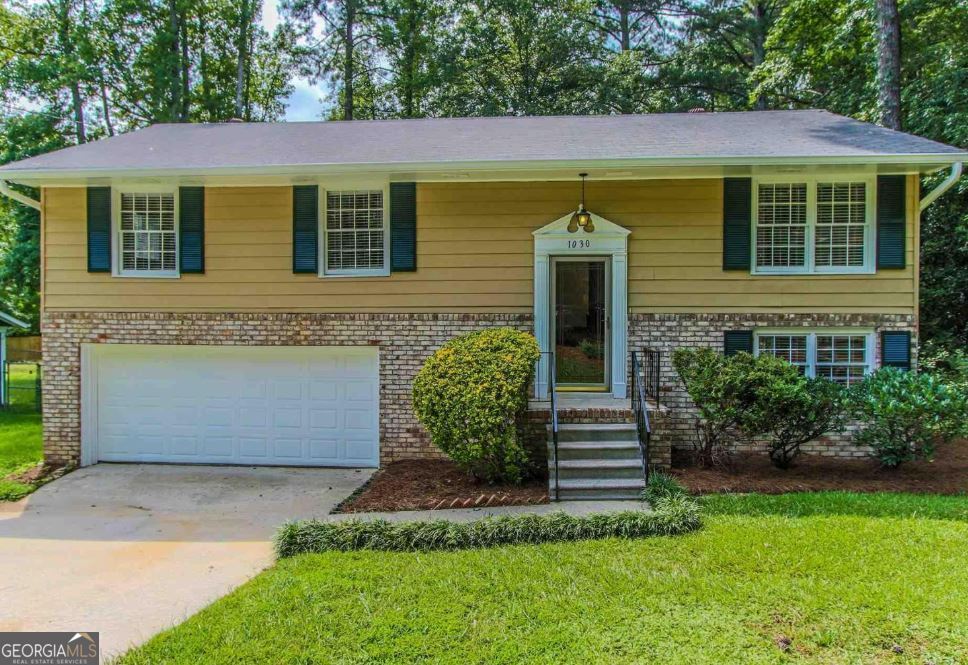 This updated brick-front home is move-in ready with a 2-car garage and fenced backyard. Recent upgrades include fresh paint inside and out, new hardwoods in the foyer and living room, new carpet, updated vanities, granite countertops, and modern light fixtures. The main level offers a large bonus room with a half bath, while the kitchen features a pantry, black appliances, backsplash, and easy access to the dining area and back deck. Outside, enjoy a lawn, fresh landscaping, and plenty of space to relax or entertain.