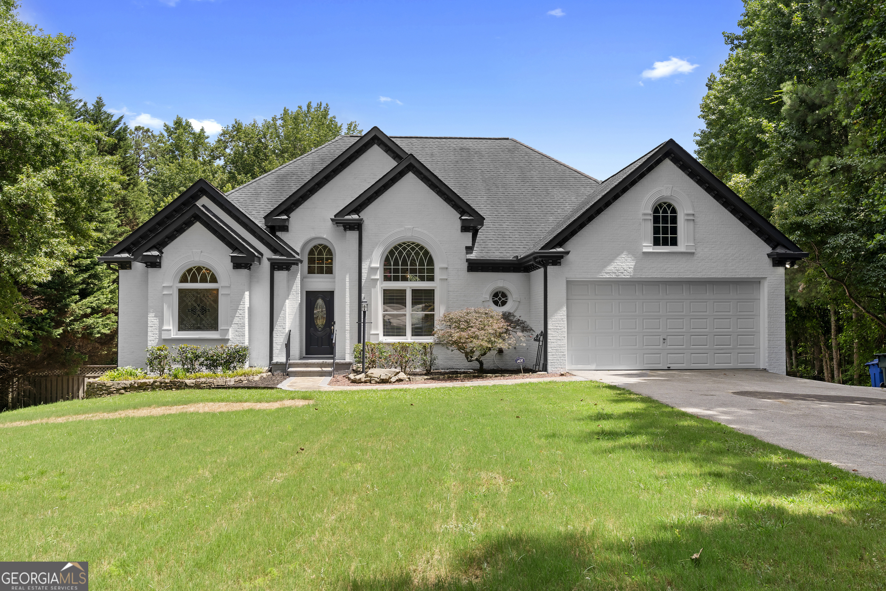 Welcome to this stunning 5 star residence, sure to impress any family or guests! This gorgeous home features a pond, pool, and deck, as well as a fully finished basement with its own kitchen and bar. The house is freshly painted with new carpeting throughout. The kitchen is complete with new quartz countertops, new backsplash, new stainless steel appliances, and white cabinetry which is adjacent to the breakfast area. The master bedroom is also on the main level with two closets and an additional walk in closet. The master bathroom contains a beautiful double vanity with new quartz countertops, a separate jacuzzi tub with stained glass window, and a shower. The main level also has two additional bedrooms with a shared bathroom, a large family area featuring a fireplace to cozy up, a separate formal dining space, a laundry room with a sink, and a half bathroom. The basement is ideal for hosting guests, repurposing as an airbnb or a separate in law suite because of its large family area with its own fireplace, and kitchen with a fridge and dishwasher. There are also two additional bedrooms, one of which leads into the backyard and has stunning barn doors. Also, there is a full bathroom with a shower tub combo and a new quartz countertop. Additionally, there is a separate garage in the basement neighboring an extra room with a large scale puppy shower for pet lovers and an extra laundry room. This house would not be complete without the large sized deck overlooking the gorgeous pool with a patio for relaxation and a stunning half acre pond with its center piece fountain and pumps, as well as a shed. For any car collectors there are a total of two, two car garages and a car port for large RVs or boats accompanied by an elegant, long driveway. NO HOA AND NO RENTAL RESTRICTION CORPORATE MEMBER/OWNER HOLDS GA RE LICENSE