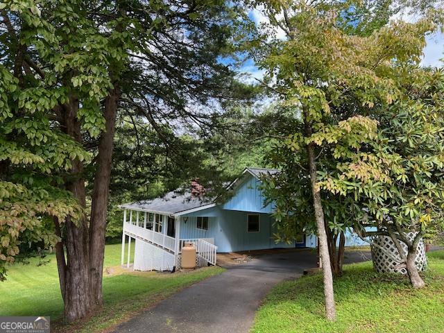 Exceptional Cabin, Year Round Creek, Recent New Roof. Renovated 2019. LG appliances F/F dishwasher cooker microwave washing m/c and dryer. LED lighting, Electrics and plumbing. Dual pane windows, Pella sliding glass doors. Exterior - Circular driveway, security light with double carport, 4 LED down lights. Front entry into foyer 11'x10', double bi fold doors at the rear, washer & dryer and storage. Master bedroom - Master shower room - vanity, his and her ceramic sinks, granite top, double linen closet. From foyer through hallway, Family Bathroom, full bath, shower over. Hallway to Den/Bedroom 2, built in cabinets and shelving. Living room (very light). Impressive Stone fireplace, Majestic Duzy gas log ceramic vented fireplace set (2 years old). Bi fold smoked glass doors when not in use. Kitchen area with pantry. Granite counters, cast iron ceramic sink, lighting over sink. Interior dining room with windows on 3 sides. Exterior screened dining room facing west, Covered deck facing south. Internal stairs lead basement.The basement has a large room, full bath, and bonus room with a closet previously used as workout room. Enjoy the soothing creek from the large screened back porch, in the yard on the swing, or by the firepit! The outbuilding has a multitude of uses. Paved road, paved semi-circular driveway with a drive through carport. Only a nice 5-minute walk to Lake Chatuge. Nicely landscaped. Wraparound porch completes this home.