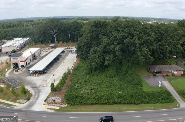 **High-Traffic Commercial Land in Stonecrest** This is an exceptional opportunity to acquire a prime **1.97-acre commercial lot** in a rapidly growing area of Stonecrest, Georgia. Situated directly on Panola Road, this property benefits from a significant and increasing volume of traffic. A 2020 Georgia Department of Transportation (GDOT) study measured the average daily traffic at approximately **17,445 vehicles**, making it an ideal location for businesses that thrive on maximum visibility and customer exposure. The flexible **C-1 "Local Commercial" zoning** is a key advantage, providing a wide range of development possibilities to serve the community's daily needs. These include: * **Retail & Services:** Perfect for specialty shops, salons, barbershops, pet grooming, an indoor recreational center (such as for pickleball), or a dry cleaner. * **Restaurants:** Capitalize on the high traffic with a sit-down restaurant, a bakery, a coffee shop, or a drive-thru fast-food establishment. * **Office & Medical:** Ideal for professional offices (law, construction, or real estate firms) and medical clinics, with convenient proximity to Rockdale and Hillandale Hospitals. * **Other Uses:** The land is also suitable for childcare, educational facilities, or automotive services. This strategic lot is at the heart of an area undergoing significant transformation, with new residential communities and prominent retail anchors like Publix and Lidl. Located directly across from the popular Lou Walker Senior Citizen Recreational Center, it offers a unique opportunity to cater to the senior demographic. This property is a fantastic opportunity for a visionary developer or investor. The seller has existing plans for a townhome community, which would require rezoning. **Disclaimer:** Buyers are responsible for verifying all information, including potential rezoning and use. Please note that while the property is officially located in the City of Stonecrest and subject to its taxes, there is a current GIS mapping discrepancy where DeKalb County tax records and the USPS may list the address as being in Decatur.