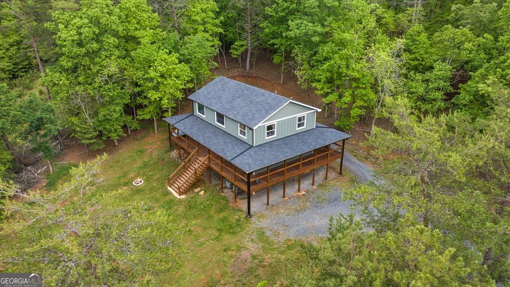 Charming Mountain Retreat with Wolf Creek Frontage & Wraparound Porches. Welcome to your ideal mountain getaway-just minutes from town with all paved road access! This beautifully crafted home offers the perfect combination of rustic charm, modern comfort, and scenic surroundings. Located just across from picturesque Wolf Creek and a short drive to Horseshoe Bend Park and the Toccoa River, this property is a nature lover's dream. Inside, you'll find an inviting open floor plan with soaring vaulted ceilings and warm wood accents throughout. The main-level primary suite provides a private sanctuary, complete with a luxurious soaking tub for relaxing after a day of adventure. Upstairs features an expansive loft area, two spacious bedrooms, and a full bath-perfect for guests, family, or a home office. Enjoy peaceful mornings and stunning sunsets from the wraparound porches, where you can hear the gentle sounds of the creek just across the road. Whether you're entertaining, unwinding, or exploring nearby outdoor attractions, this home offers the best of mountain living-all within minutes of town.