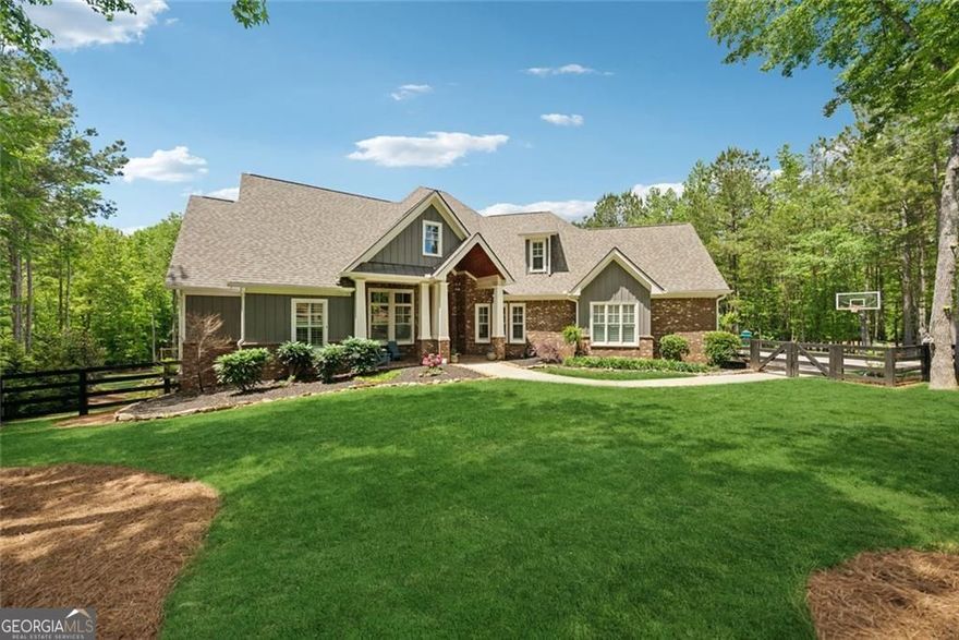 Privately situated on 2.23 acres in the prestigious Estates at Serenity Farm, this 6-bedroom, 5-bathroom residence offers 6,625 square feet of luxurious living space, enhanced by thoughtfully curated upgrades both inside and out. A true entertainer's dream with a resort-style backyard pool and designer interiors, this home offers elevated everyday living in the heart of Southeast Cherokee County. Step into a grand two-story foyer that opens to an inviting great room with wood-beamed ceilings, a cozy fireplace, and a wall of windows. The open-concept kitchen is a showstopper-featuring upgraded stone countertops, a large prep island with built-in microwave, and a spacious eat-in peninsula perfect for casual dining. A stylish gray herringbone subway tile backsplash adds texture and polish, while the 6-burner gas range, stainless steel appliances, walk-in pantry, and custom cabinetry complete the chef's space. The breakfast area and fireside keeping room flow effortlessly into the screened porch with a second fireplace for year-round enjoyment. The main-level primary suite offers a spa-inspired bathroom with dual vanities, oversized shower, soaking tub, and two walk-in closets with direct access to the laundry. Two additional main-level bedrooms share a Jack-and-Jill bath with built-in study nook, and a fourth ensuite bedroom offers flexibility for guests or a home office. Upstairs you'll find a private guest suite with full bath and sitting room. The daylight terrace level has been beautifully finished with 2,689 sq ft of flexible space, including a media room with 7:1 surround sound and noise-dampening ceiling, a full wet bar kitchen with beverage coolers, ice maker, and kegerator, a family room that opens to the covered patio, gym, and game room. An additional bedroom, full bath, and second laundry room offer the perfect setup for multi-generational living or as a teen suite. Outdoors, a newly completed pool and spa create a five-star experience at home-featuring an 18'x36' heated pool with tanning ledge, 8'x8' spa, in-floor cleaning system, travertine decking, copper fire bowls, and a gas stone fire pit. The fully fenced backyard has been professionally transformed with new grading, stone retaining walls and steps, lush Zeon Zoysia sod, full irrigation with drip system. Additional upgrades include plantation shutters throughout, under-decking for the covered porch, and a fourth HVAC unit added. A spacious 3-car garage and a prime location close to Milton, Alpharetta, and top-rated schools make this property a rare opportunity in one of Cherokee County's most desirable estate communities.