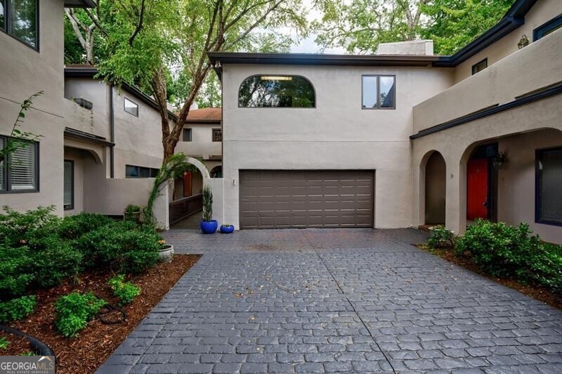 Buckhead's true hidden gem is this 2 bedroom townhome in the Case Bella neighborhood. Unit E has just been freshly painted, the kitchen and full baths have been renovated, its move-in ready! Entrance foyer leads to living room with fireplace and access to the porch. Formal dining room sits in the front of the unit. Kitchen has stone countertops, white cabinetry as well as an breakfast area. Spacious laundry room off of the 2 car garage, as well as powder room. Upper level staircase leads to two bedrooms both with en-suite baths. The secondary bedroom sits in the front of the unit and has an sunroom. The primary suite has a vaulted ceiling, walk-in closet and spacious primary bath with dual vanities, separate shower and garden tub. The upper level also offers a bonus space with wet bar and fireplace. Great for another living space! This unit has a great use of space, living areas are spacious and two separate outdoor spaces. Truly a must see in Buckhead! This quiet community has a total of six townhomes.