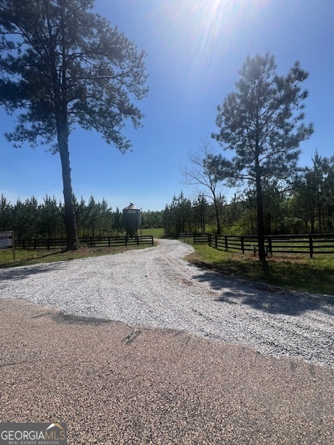 176 acres of prime land in Woodbury, Georgia-A true country retreat or future home place. Discover an exceptional 176-acre property in the heart of Woodbury, Georgia. This stunning tract of land boasts 1,200 feet of road frontage, 5-ACRE LAKE SITE, along a well-maintained paved road, offering easy access and endless possibilities for a variety of uses. With over 120 acres of 8-year-old loblolly pine trees already planted, this property presents an incredible opportunity for forestry, farming, or simply enjoying the beauty of nature. A standout feature of the property if the well-built 30 x 60 pole barn with electricity and power hookups, making it ideal for storing equipment, or even accommodating campers. Whether you're looking for a recreational retreat or a working farm, the pole barn offers convenience and versatility. A highlight of this expansive property is the picturesque Pappy's Creek, which runs gracefully through the back portion, carving out a serene bottom. This natural water source adds character to the land, offering potential for wildlife viewing, fishing, or just enjoying the peaceful sound of running water. The combination of woodland, water, and open space makes this property an incredibly rare find. Whether you're seeking a private sanctuary, a hobby farm, or a profitable investment, this 176-acre property has the space and features to meet your needs. Don't miss out on the chance to own a piece of Georgia's countryside with the perfect balance of solitude and access. This land is ready to become whatever you envision.