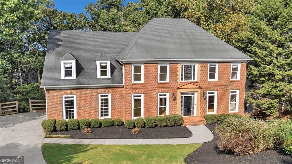 Welcome to 710 Leeds Garden Terrace, a distinguished residence in the highly sought-after Chartwell community. This elegant 6-bedroom, 5-bath home offers over 5,000 square feet of beautifully designed living space, blending timeless architecture with modern comforts. Set on a landscaped lot surrounded by mature trees, the 3.5-sided brick exterior creates an inviting first impression. Step inside to a grand two-story foyer accented by refinished hardwood floors and walls of windows that flood the interior with natural light. The main level showcases a formal dining room, a versatile guest suite or office, and a stunning two-story family room anchored by a stacked-stone fireplace. The heart of the home is the chef's kitchen, thoughtfully designed with granite countertops, a large center island with seating, stainless steel appliances, and an adjoining fireside keeping room-ideal for gathering with family and friends. Upstairs, retreat to the primary suite, a private oasis featuring tray ceilings, a covered deck, a spa-inspired bath with soaking tub and separate shower, and an expansive walk-in closet. Three additional bedrooms and a loft provide flexible living space for guests, work, or play. The finished terrace level expands your living options with a full apartment including a kitchenette, bedroom, bathroom, and a fireside living area. A dedicated craft room and ample storage make this level as functional as it is inviting. Outdoor living is a true highlight with three covered decks, a patio, and a firepit overlooking the private backyard. Direct access to Newtown Park offers walking trails, a dog park, playgrounds, and an amphitheater just steps from your door. Residents of Chartwell enjoy resort-style amenities including a pool, tennis courts, pickleball, playground, clubhouse, and sidewalks, all within a welcoming neighborhood atmosphere. Blending Southern charm, luxurious design, and unbeatable location, 710 Leeds Garden Terrace is a rare opportunity in Roswell. Schedule your private showing and experience this exceptional home today.