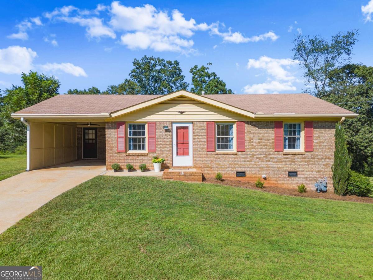 Beautiful Brick Ranch on .63 Acres in Flowery Branch - No HOA! Finally, an affordable, charming 3-bedroom, 1-bath brick ranch, with a large bonus sunroom on a level .63-acre lot in a quiet, established neighborhood in desirable Flowery Branch. This property built and lived in by original owner offers privacy, convenience, and freedom with no HOA restrictions. Recent updates include freshly painted interior and exterior doors and shutters, new vents, light plates, and light fixtures. Brand-new flooring in the kitchen, sunroom, and bathroom, creating a clean and inviting feel throughout. New water heater 2023. The spacious sunroom adds flexibility to fit your lifestyle-perfect to convert as a home office, playroom, recreation room, or a relaxing retreat with peaceful views of the expansive backyard and wooded area beyond. Outdoor the level lot provides endless potential-whether you dream of gardening, creating outdoor living spaces, or simply enjoying nature. This home is a rare find, offering the best of quiet living while still being close to shopping, dining and easy access to I-985. Convenient to Platt Park that offers pickle ball and basketball courts, playgrounds, ball fields, pavilion/tables, and more.
