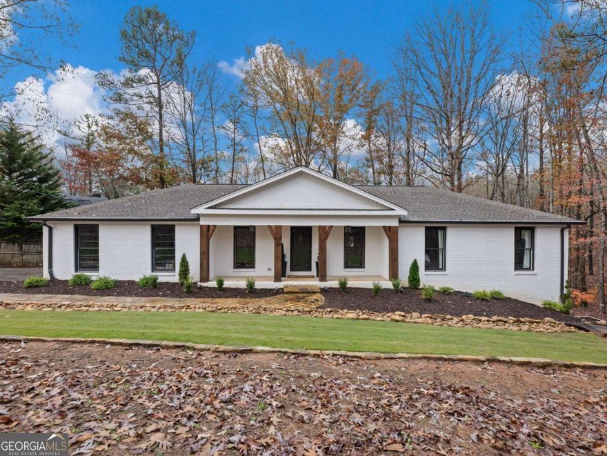 Welcome to this beautifully renovated lake home with a rocking chair front porch, nestled in the peaceful area of Hall County. Minutes to Dawsonville, Dahlonega, and Gainesville! 10 minutes to the new hospital in Dawsonville! Featuring a covered single-slip dock, this property offers serene lakefront living. The home has been completely updated with a new roof, new HVAC, and fresh paint on all four sides. Inside, you'll find a spacious, modern layout with a brand-new sunroom addition that fills the home with natural light. The basement boasts a self-contained mother-in-law suite with easy access from both the inside and outside. Whether you're looking for a short-term or long-term rental property, or a tranquil full-time residence, this home is the perfect retreat. After driving down the long driveway, you will enter the home with all new LVP flooring throughout, formal dining room, formal office room, family room with wood burning fireplace and all new lighting throughout. The kitchen renovation exudes class with the brand new shaker cabinetry with soft close feature and neutral natural stone granite countertops and tile backsplash. The open shelving area gives the kitchen a high end feel along with the all new stainless steel appliances throughout. The primary suite has a walk-in closet with closet system, a small nook filled with natural light to get ready for your day and a totally renovated bathroom with all tiled from floor to ceiling shower with dual vanities. The secondary bedroom and the renovated full bath is stunning and has plenty of storage/drawers in the new vanity. The spiral staircase takes you down to the basement that is set up perfectly for an in-law suite or a perfect place to have a rec space with a full bath, storage room and double closets. There is also a wet bar area that can be used for a coffee bar, wine bar, or add a mini fridge and microwave to now have a kitchenette space. The sunsets are unreal at this home that you can see the water from the back deck. The outdoor firepit area is the ideal spot to share your memories and roast smores. This is the home you have been looking for that is turnkey.